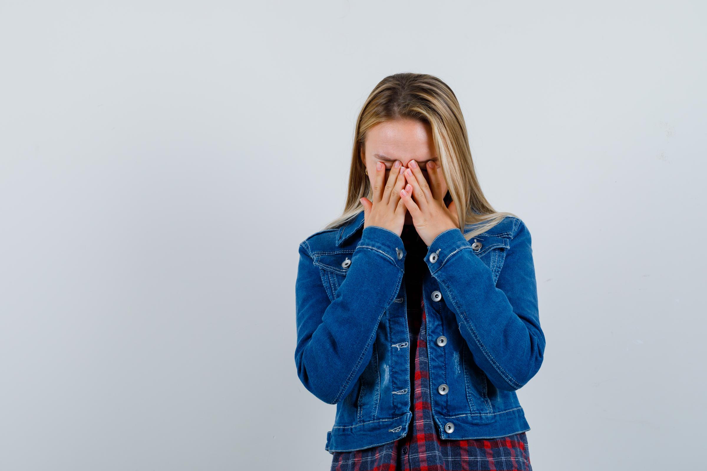 Una adolescente cubriéndose la cara con las manos | Fuente: Freepik