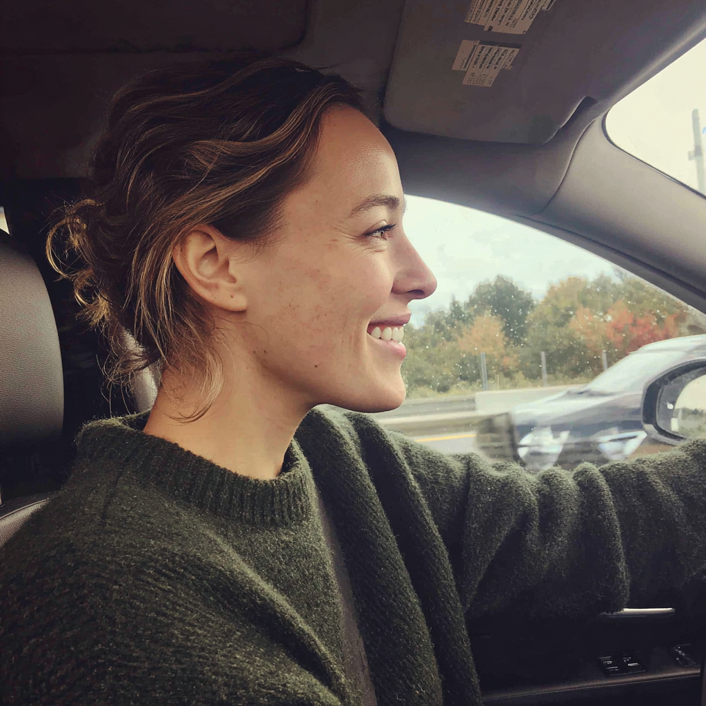 Una mujer sonriente conduciendo un automóvil | Fuente: Midjourney