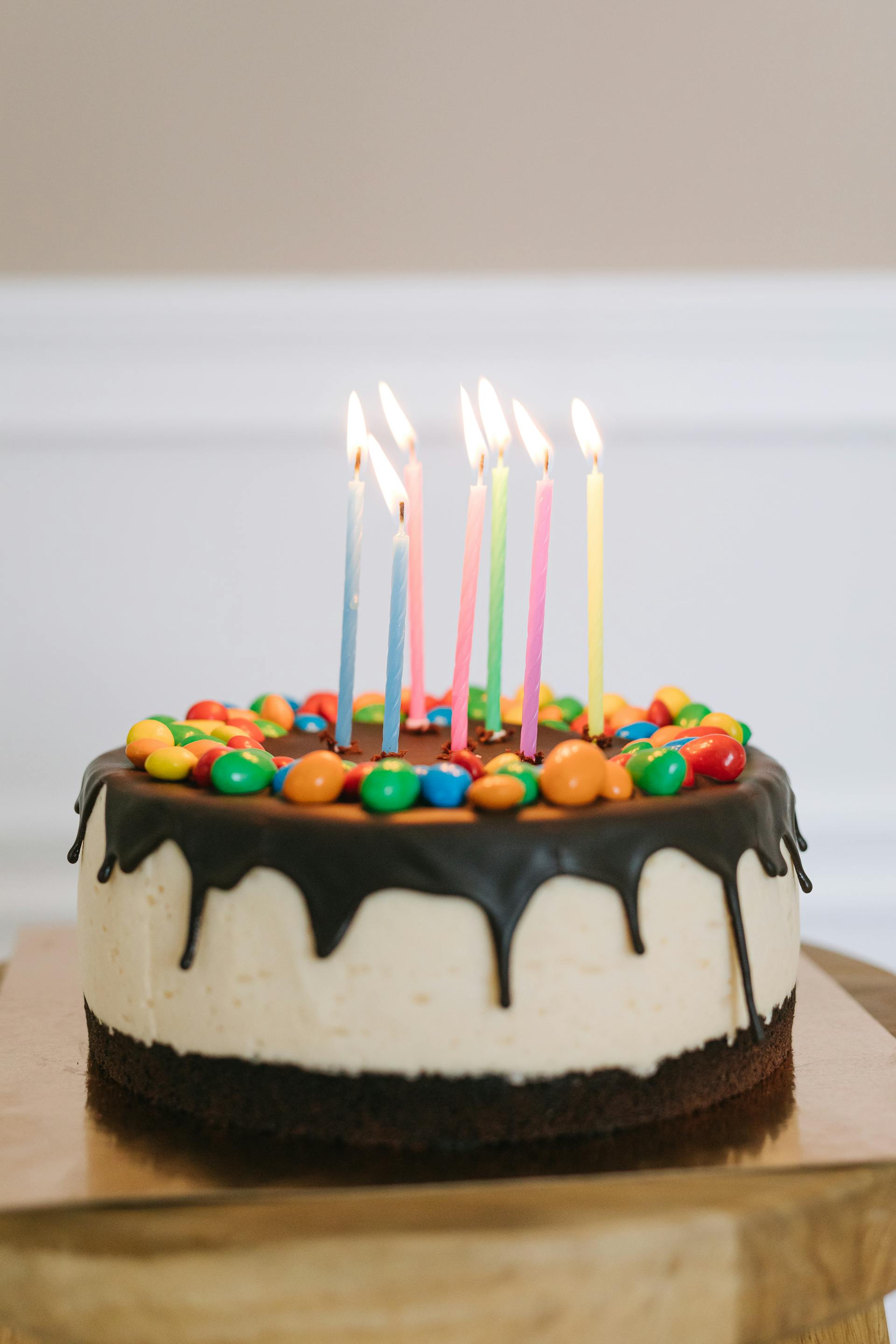 Pastel con velas encendidas | Fuente: Pexels