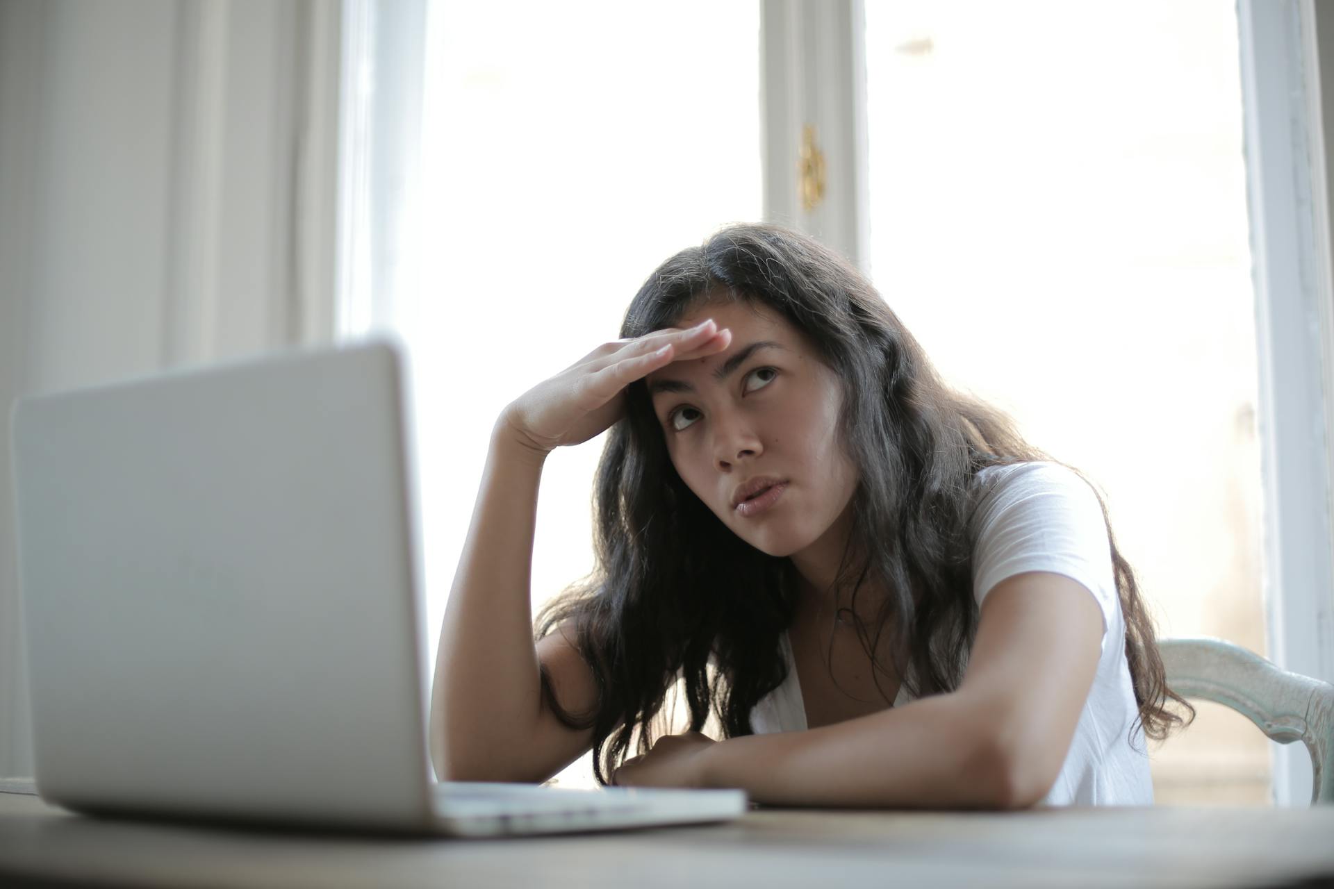 Una mujer con cara de fastidio durante una videollamada | Fuente: Pexels