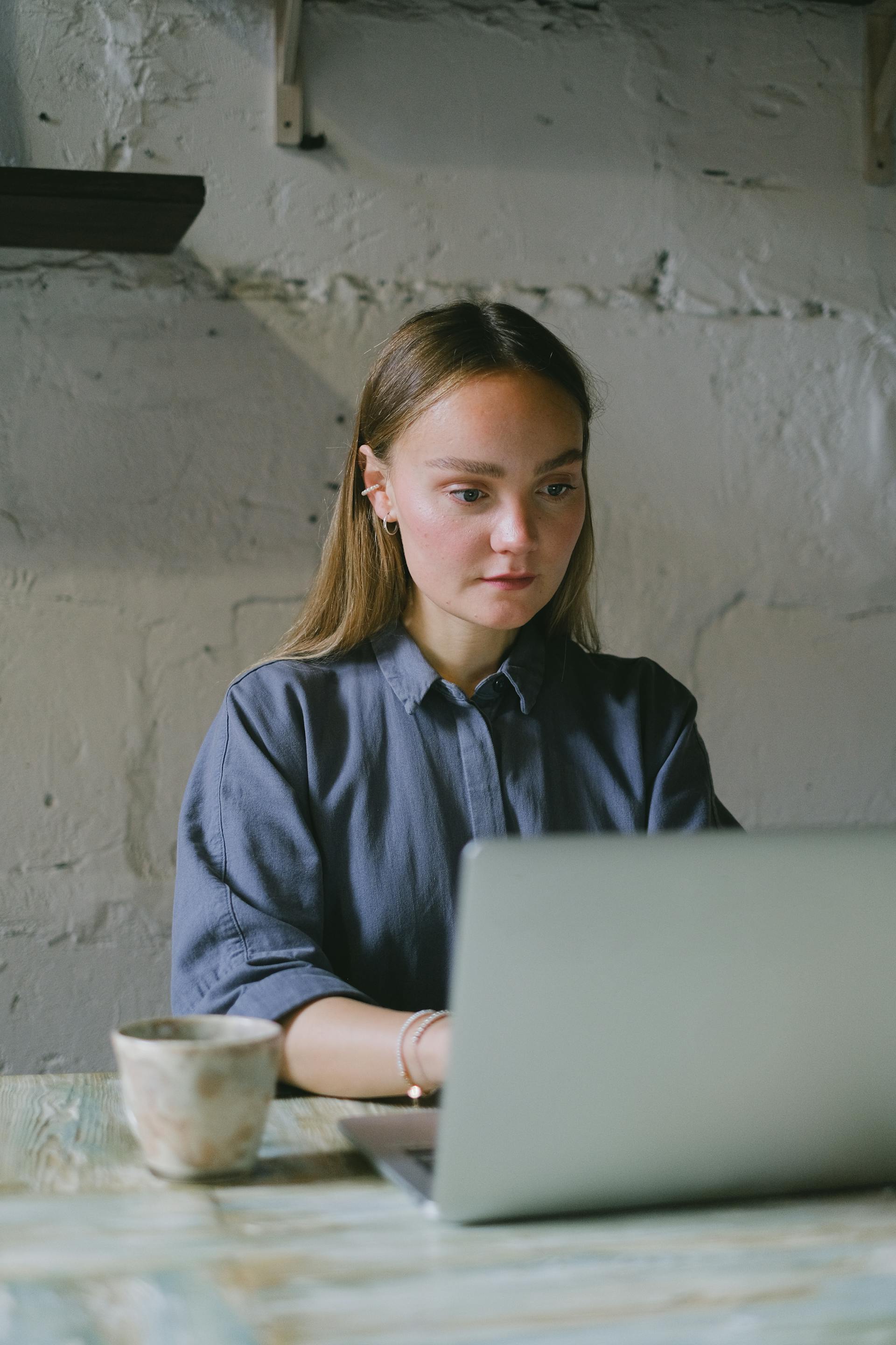 Una mujer mirando atónita la pantalla de un portátil | Fuente: Pexels