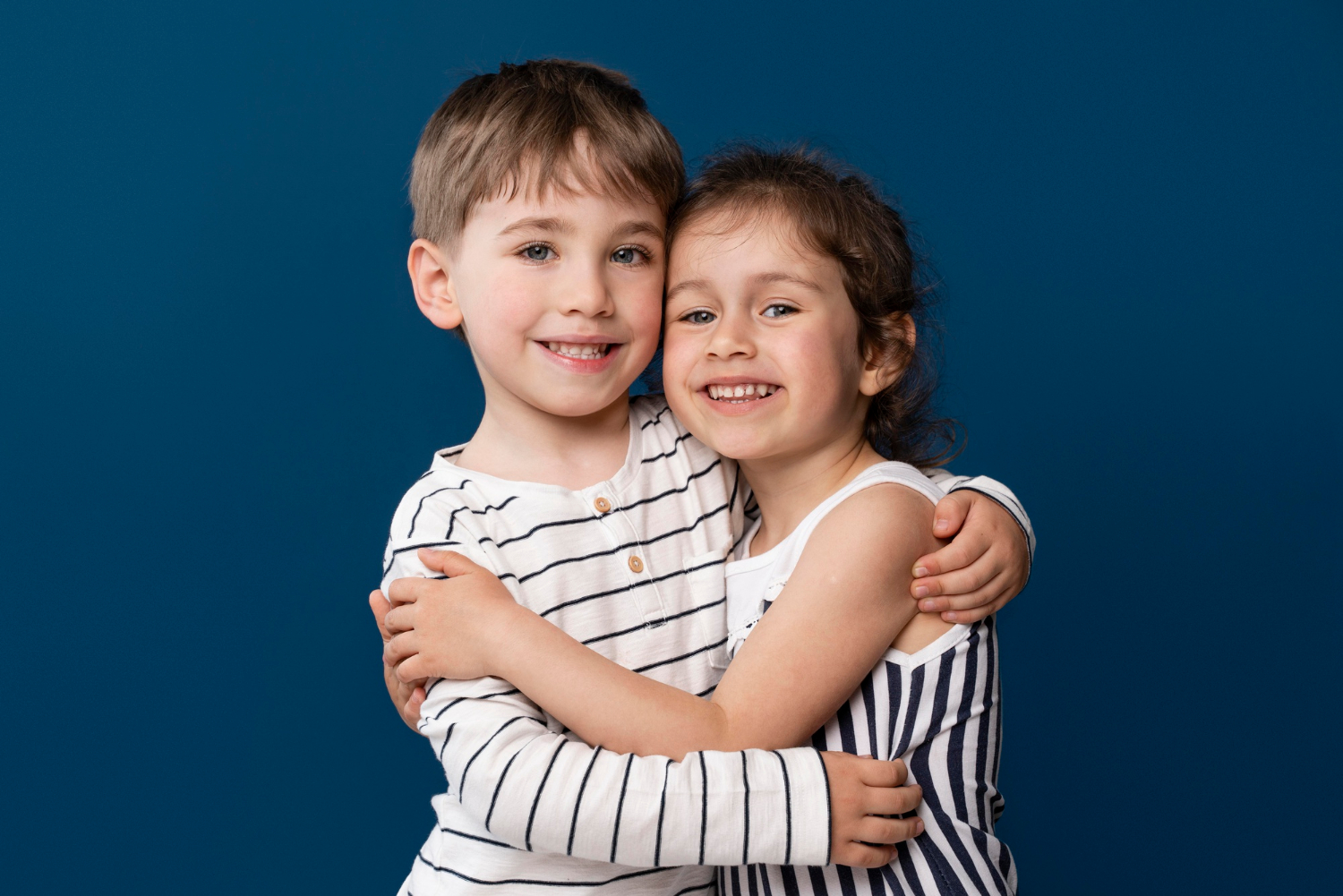 Dos alegres niños abrazándose | Fuente: Freepik