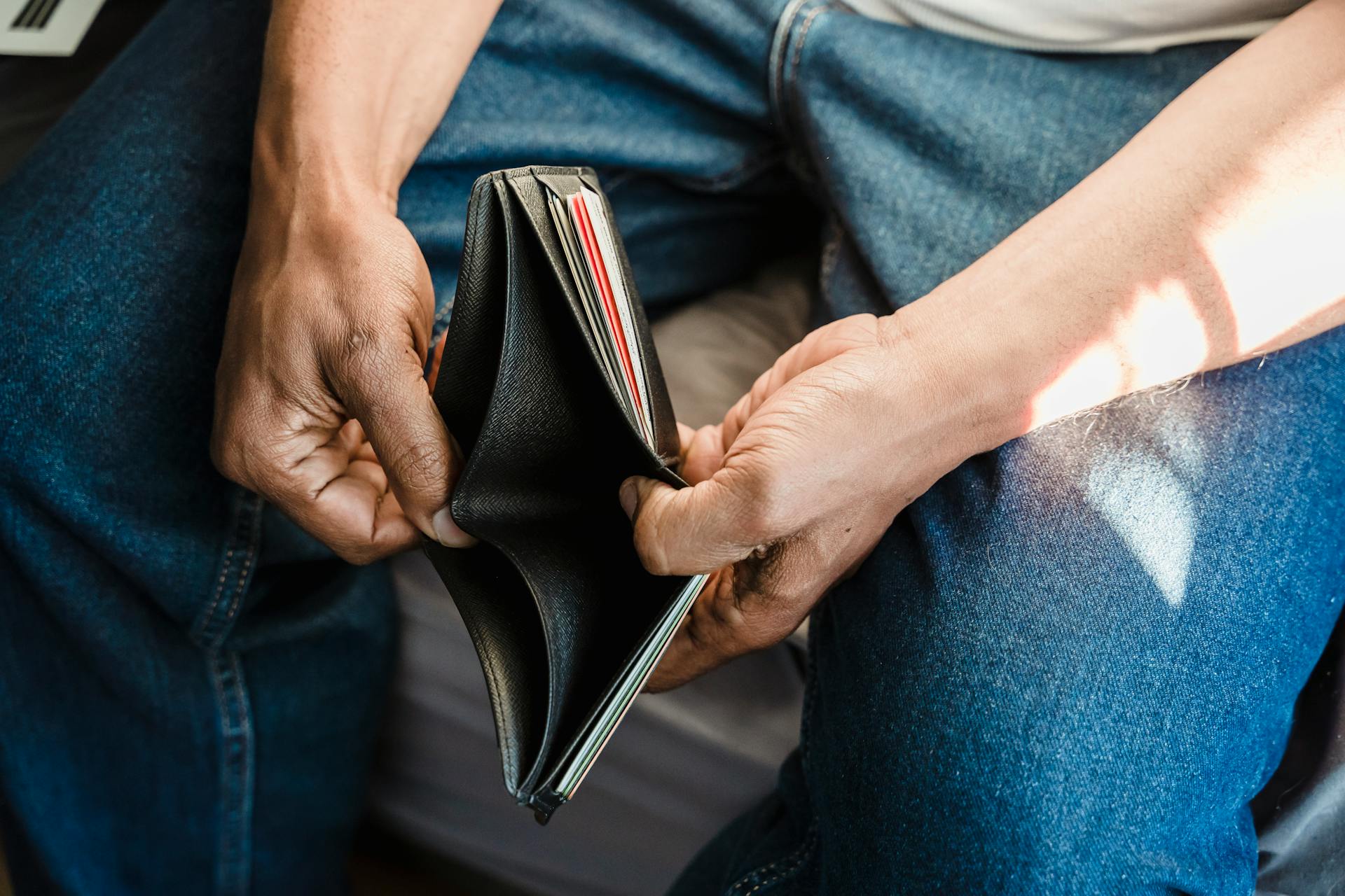 Un hombre sujetando su cartera | Fuente: Pexels