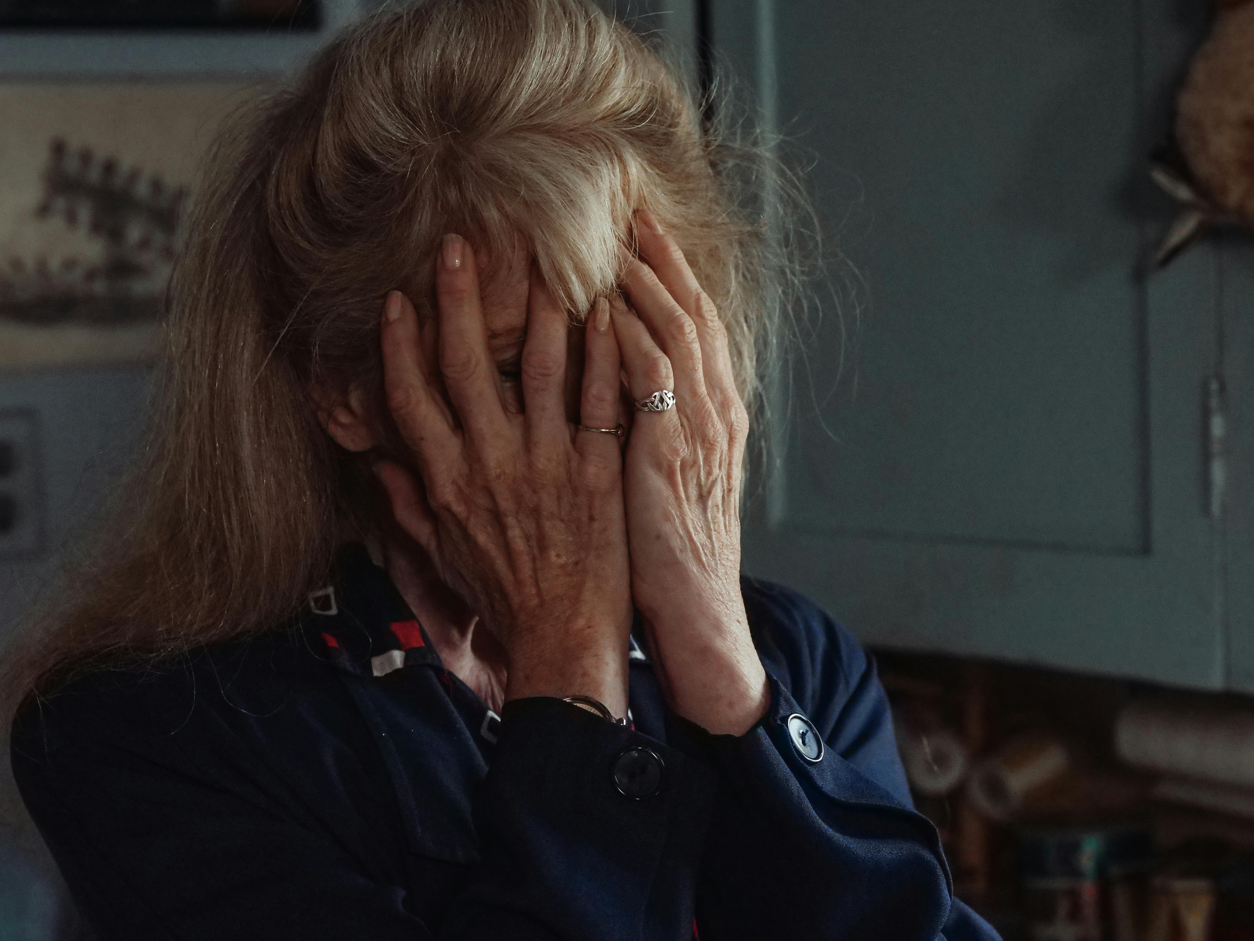 Una anciana cubriéndose la cara con las palmas de las manos | Fuente: Pexels