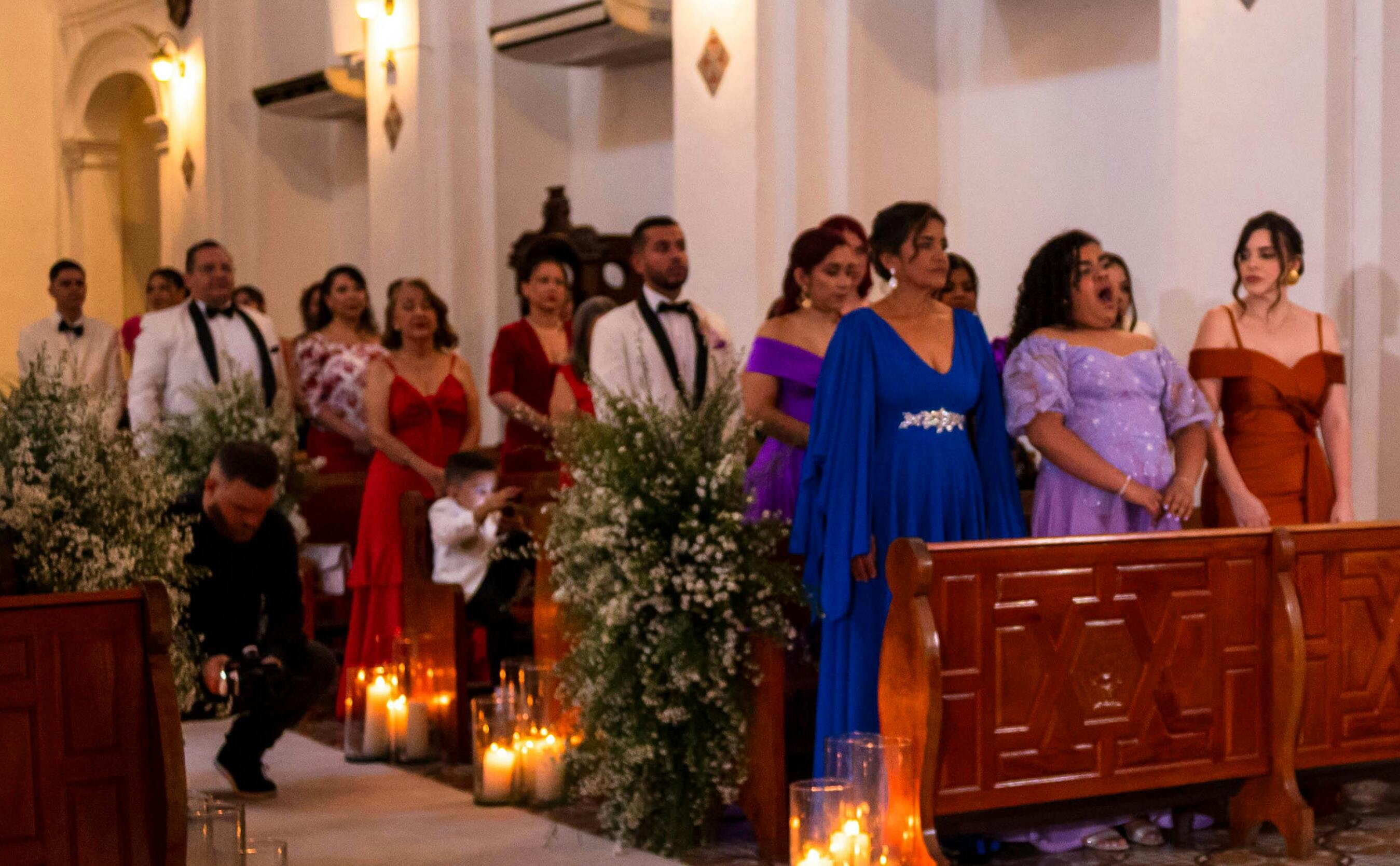 Invitados a la boda de pie junto a los bancos | Fuente: Pexels