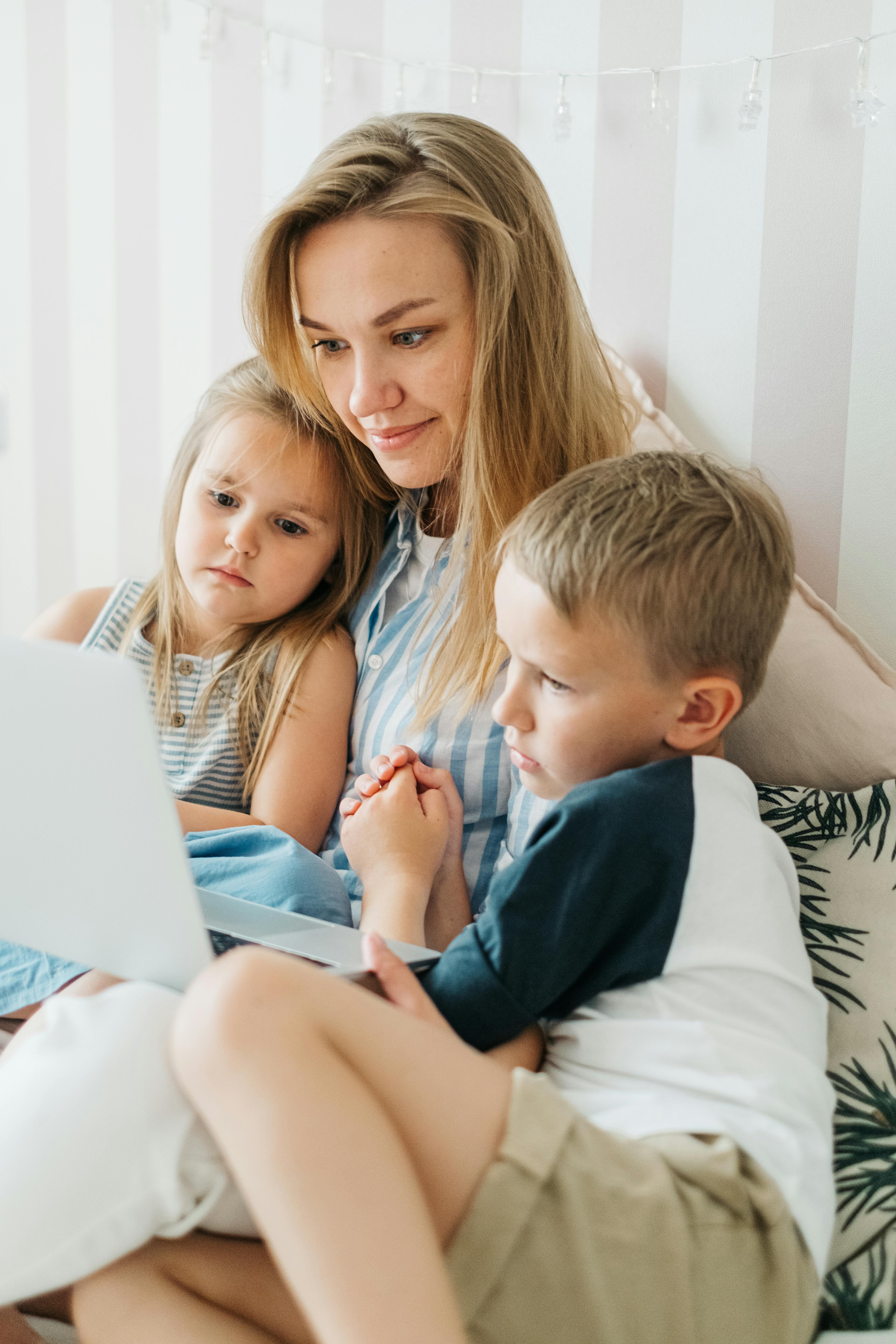 Una mujer y sus hijos utilizando un ordenador portátil | Fuente: Pexels