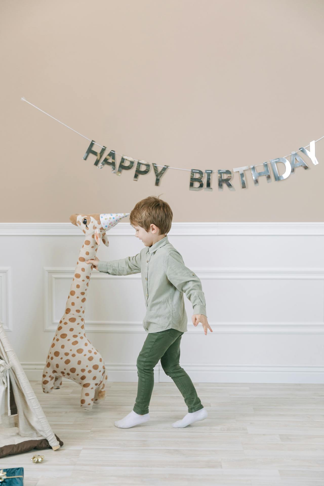 Un niño encantado con un peluche de jirafa en la mano | Fuente: Pexels