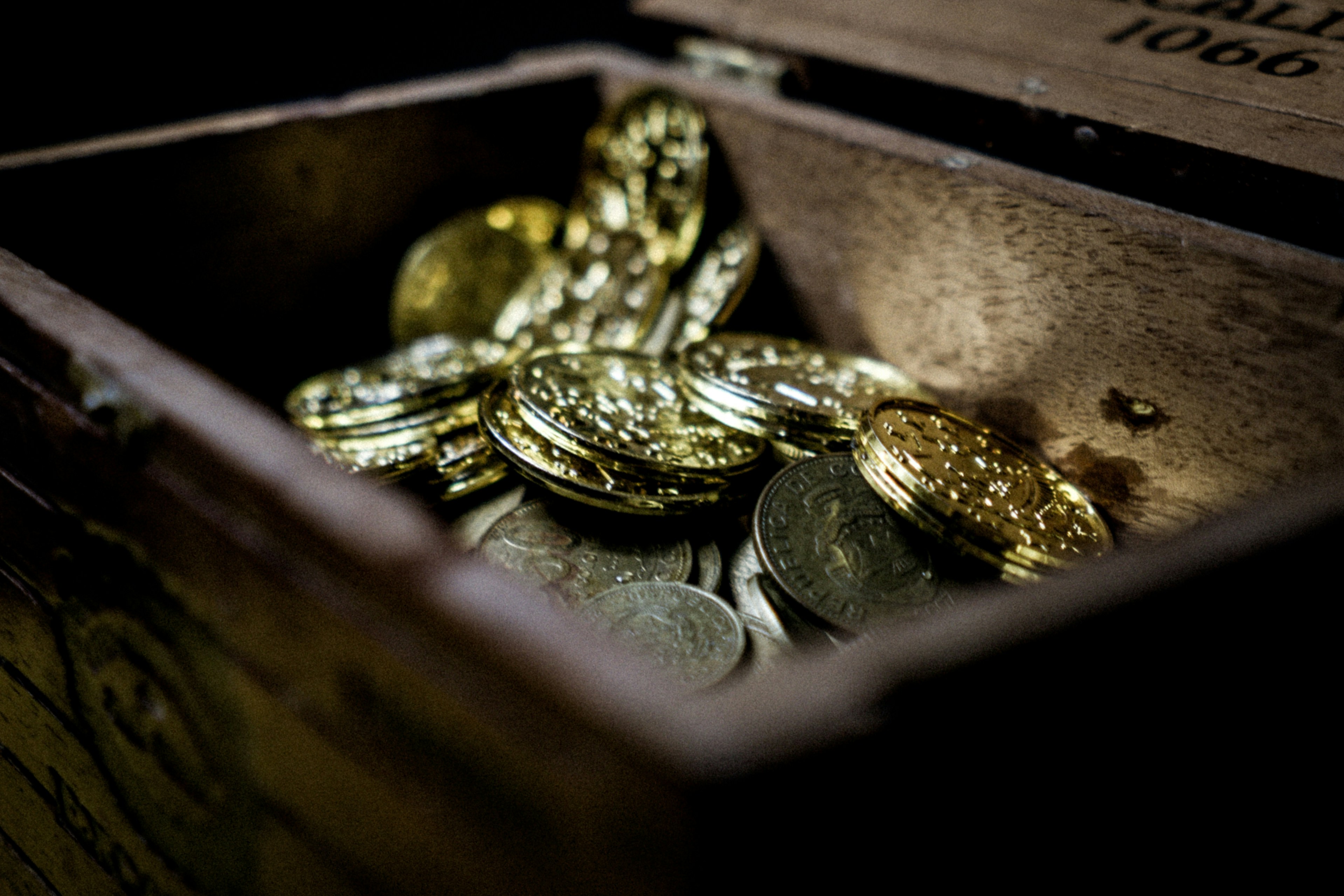 Caja de madera llena de montones de monedas | Fuente: Unsplash