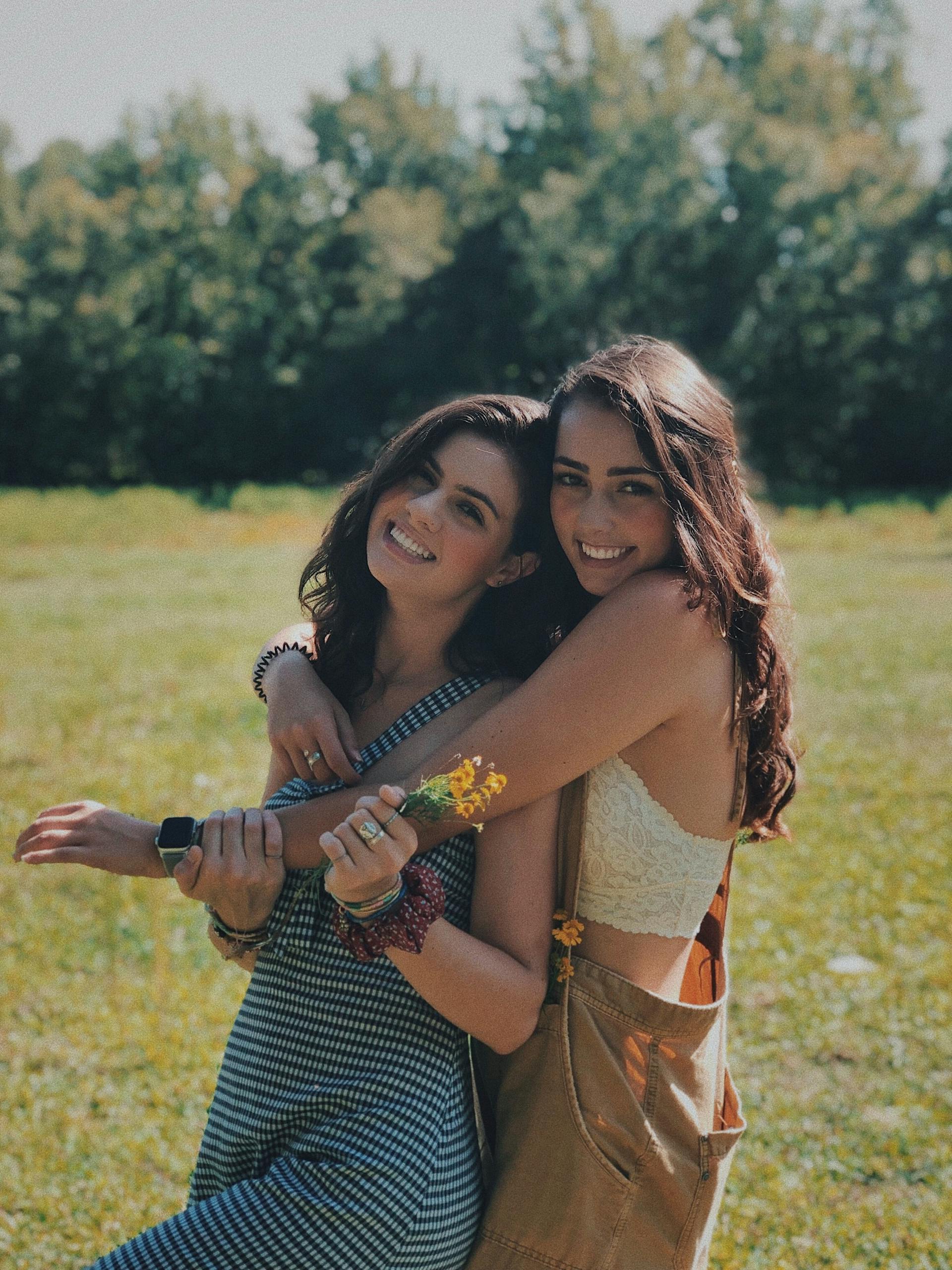 Jovencitas sonrientes abrazándose | Fuente: Pexels