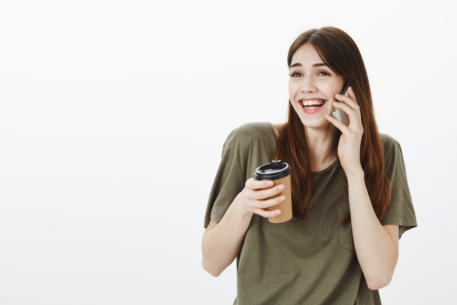 Una mujer con una taza de café en la mano y riendo mientras habla por teléfono | Fuente: Freepik