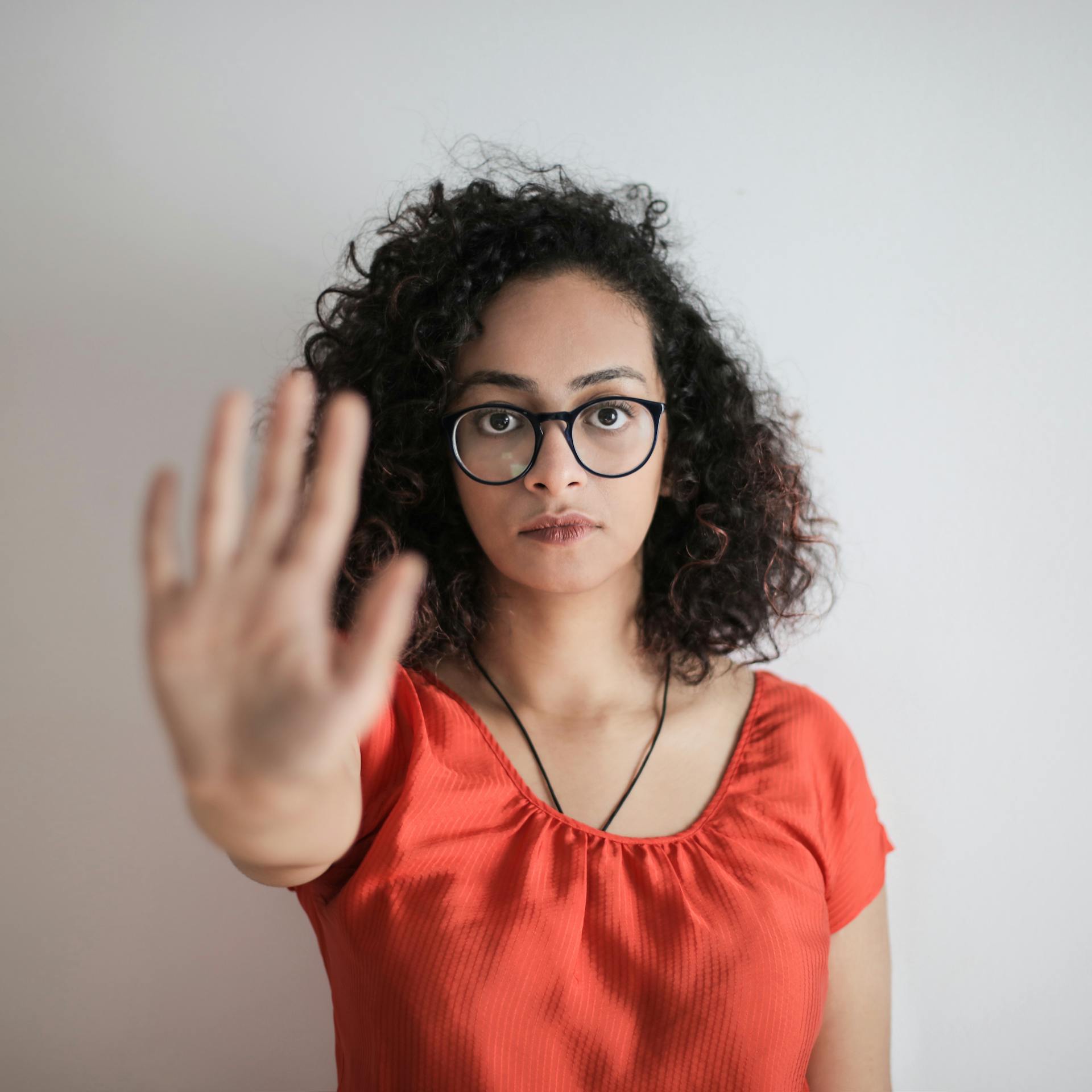 Una mujer extiende la mano en señal de "alto" | Fuente: Pexels