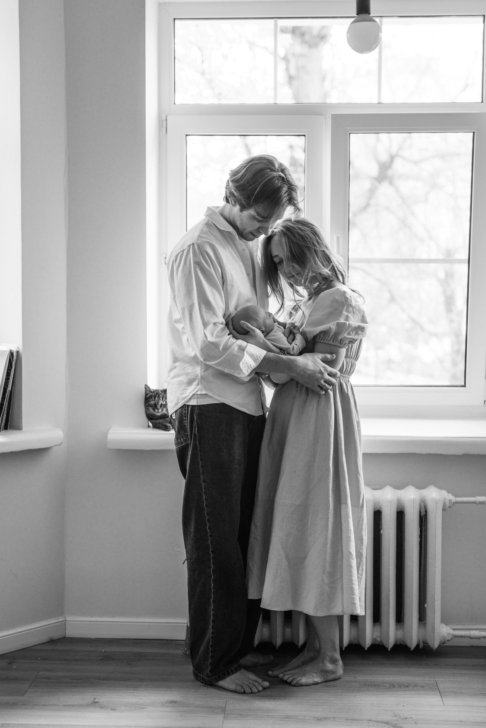 Foto en escala de grises de una pareja sosteniendo a un bebé recién nacido | Fuente: Pexels