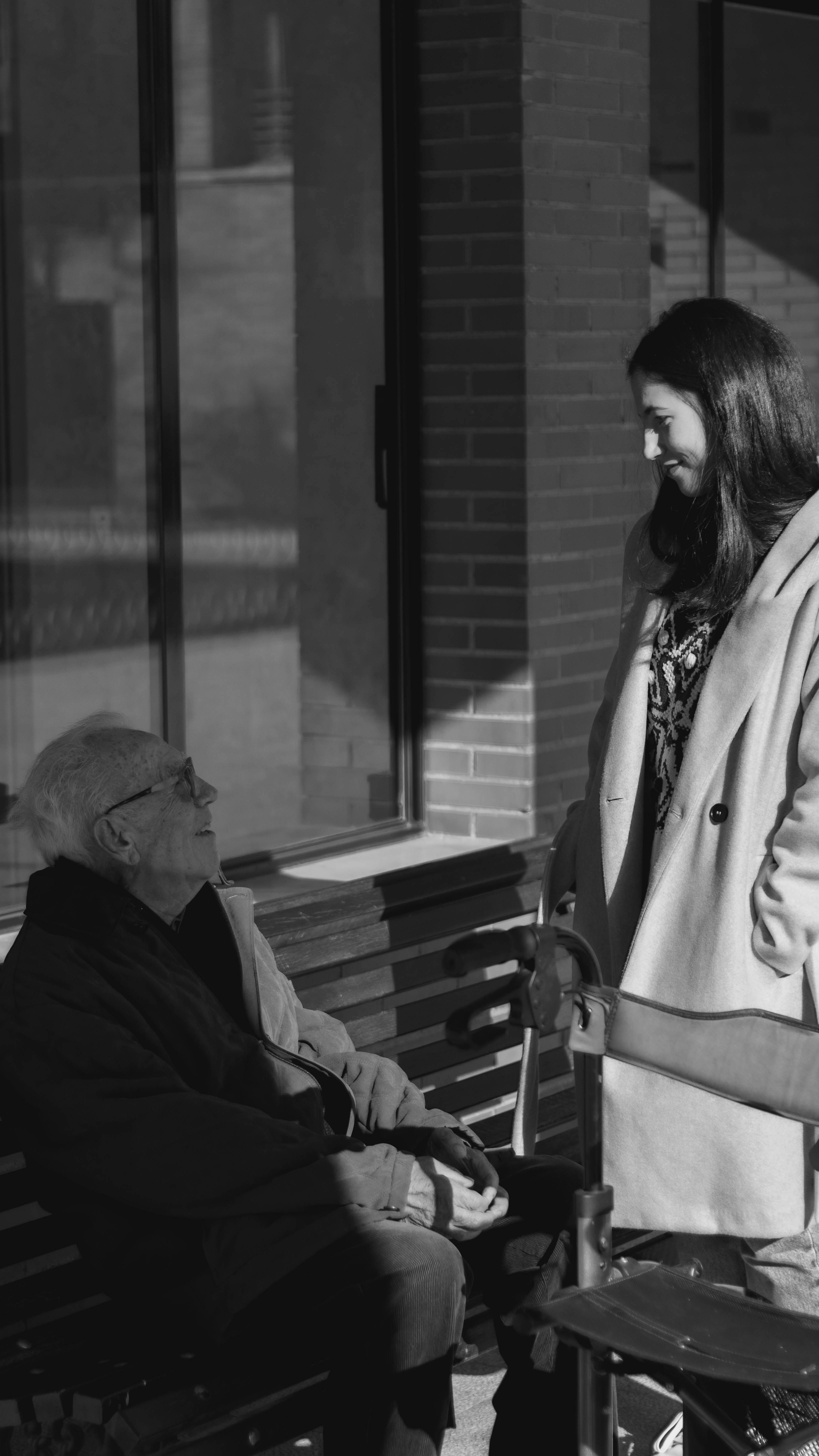 Anciano sentado en un banco hablando con una mujer | Fuente: Unsplash