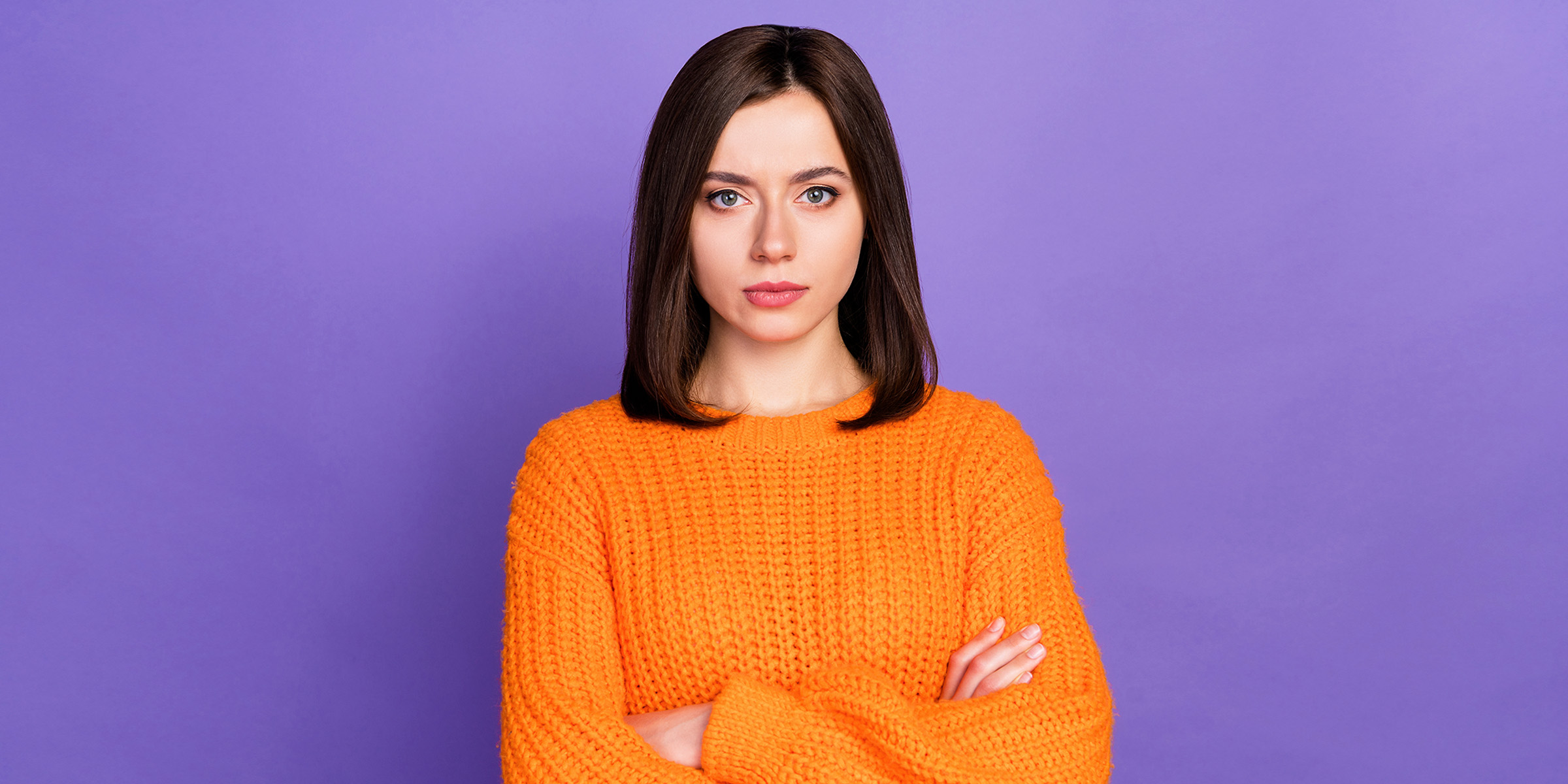 Una mujer de pie con los brazos cruzados | Fuente: Shutterstock