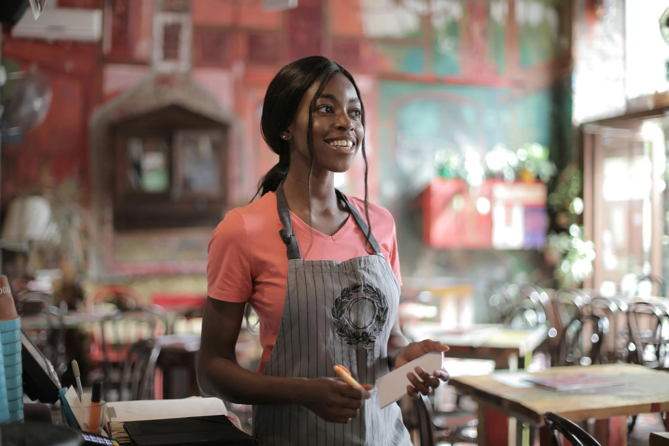 Una camarera sonriente en un pub | Fuente: Pexels