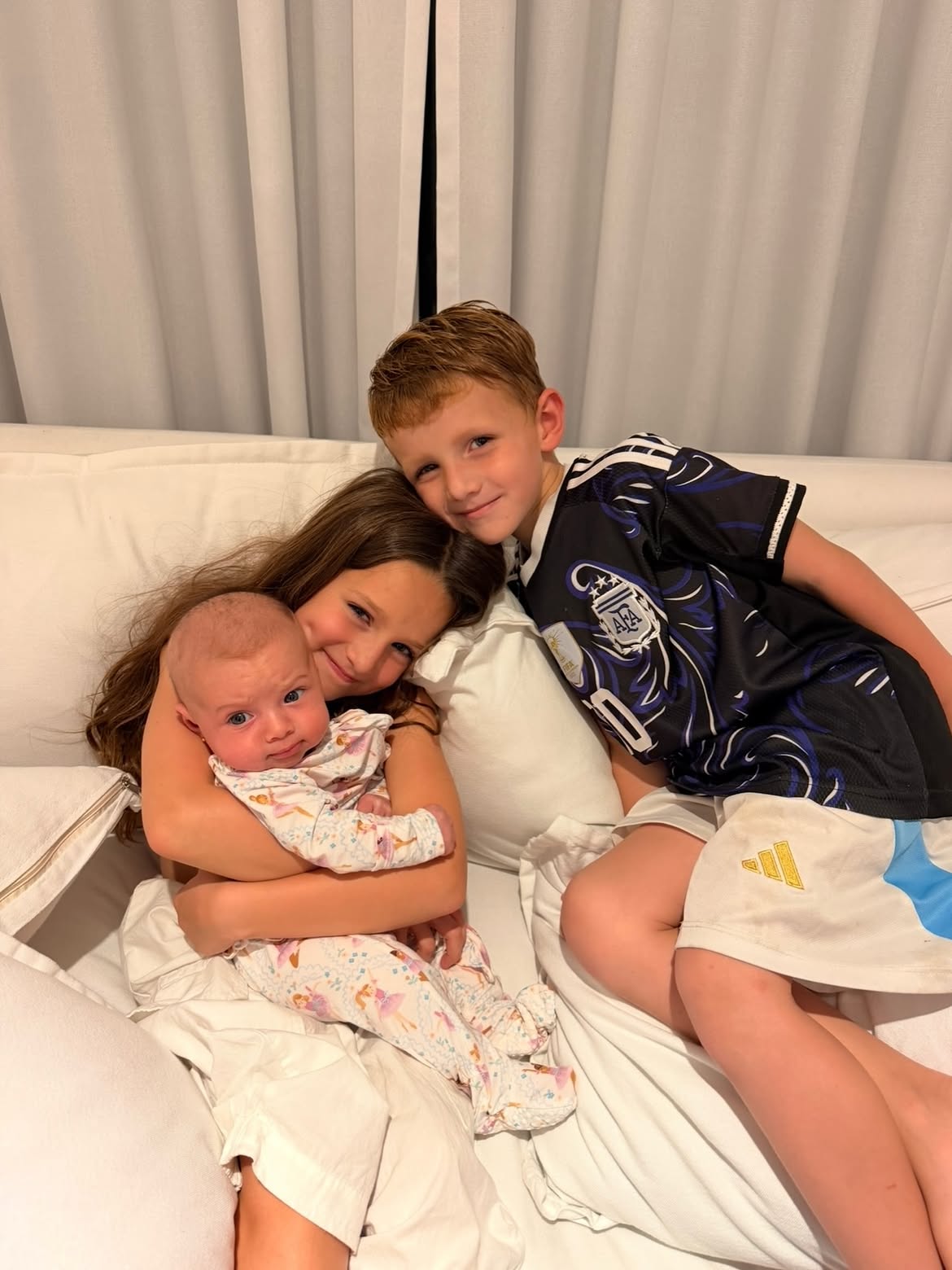 Bautista, Francesca y la bebé Aitana, hijos de Cami Homs, en un sofá | Fuente: Instagram/ camihoms