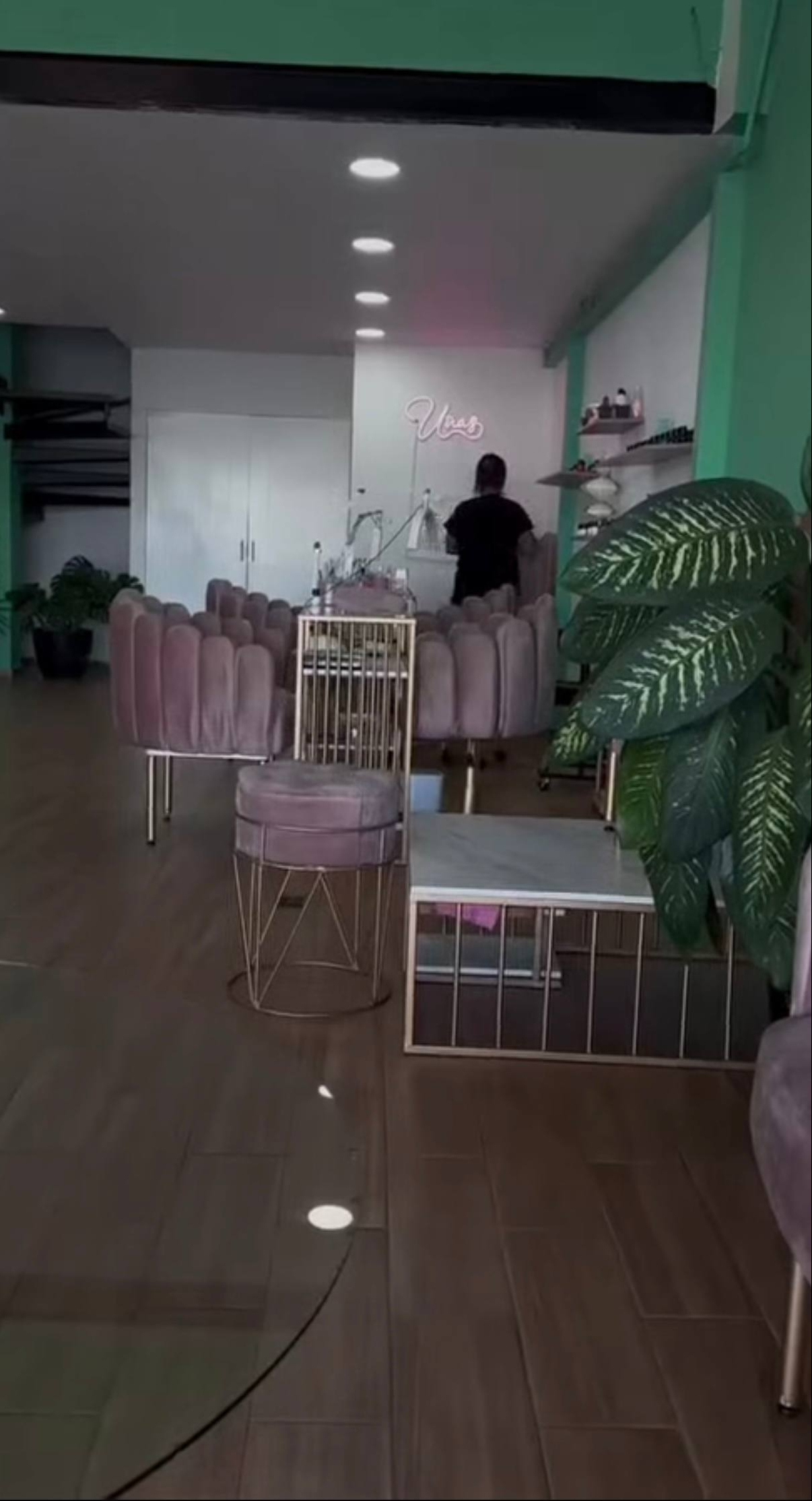 Interior del local de Valeria Márquez con piso de madera, muebles y sillas de color rosa | Fuente: Instagram/blossom.beauty.ig