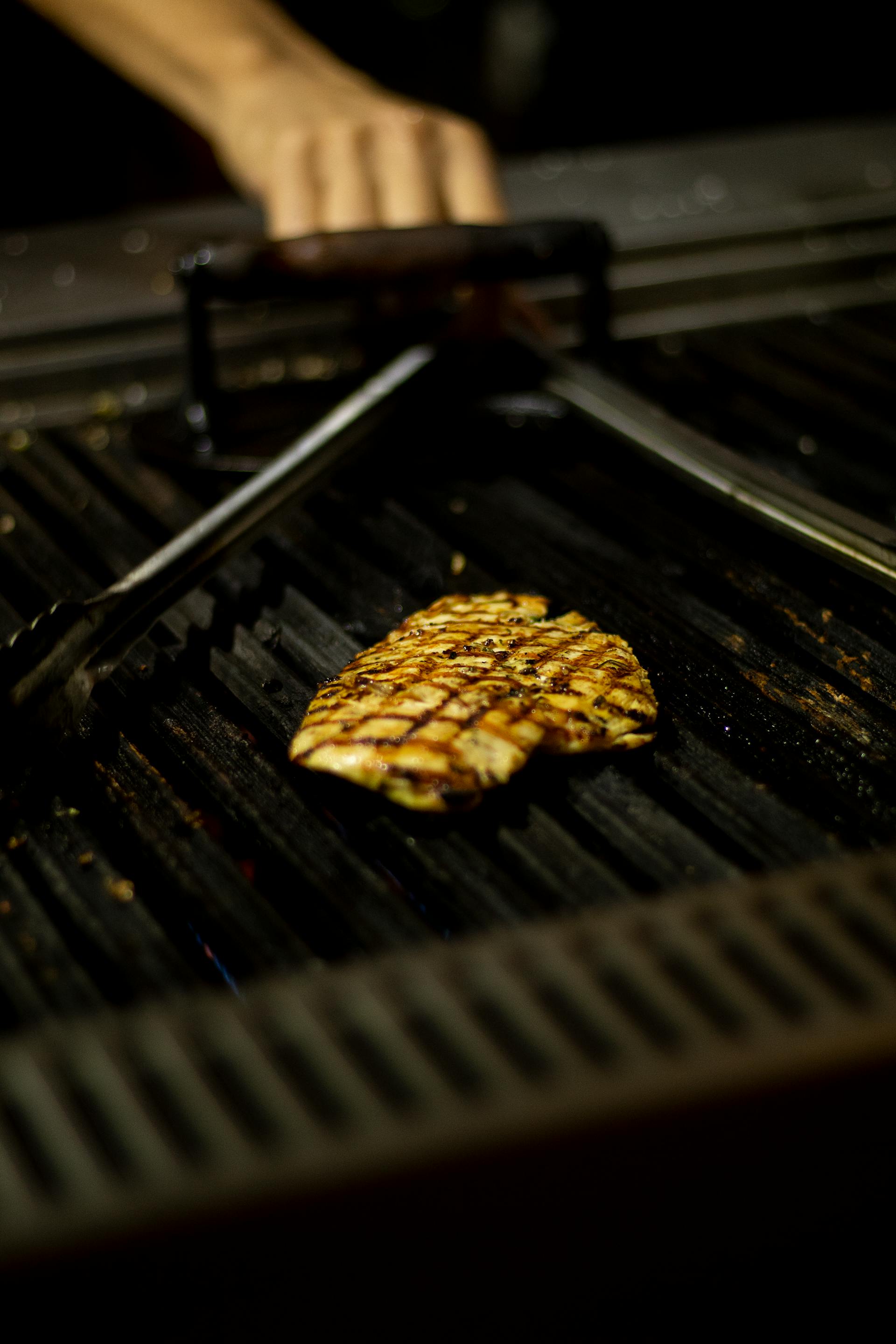 Una pechuga de pollo cocinándose en una parrilla | Fuente: Pexels