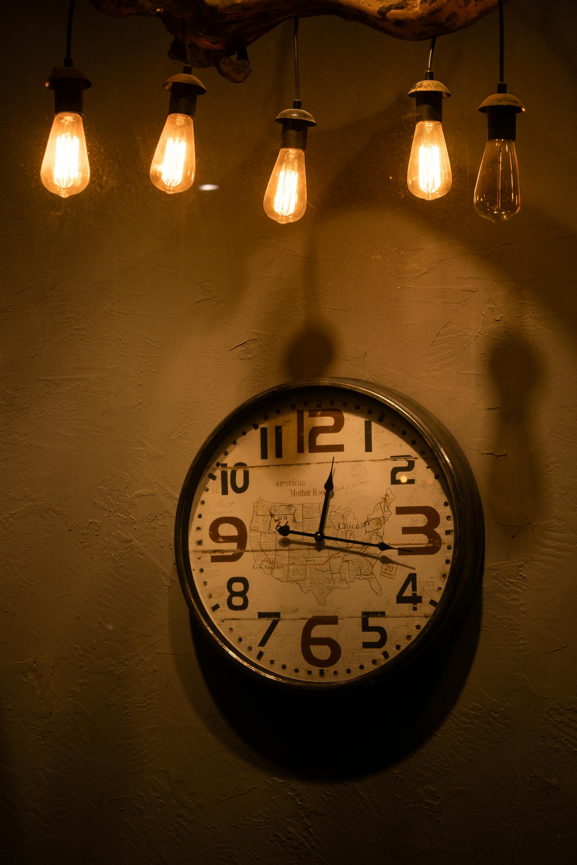 Bombillas colgando sobre un reloj analógico | Fuente: Pexels