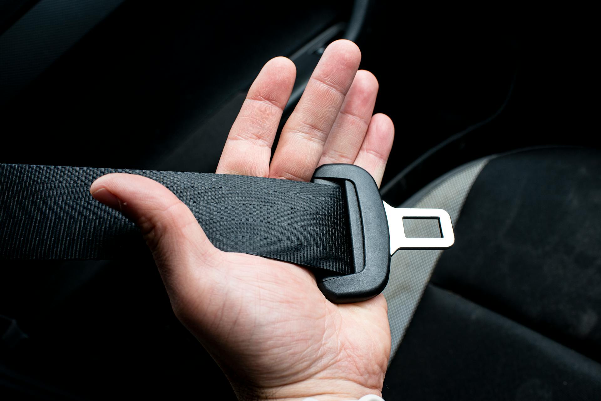 A person putting on a seatbelt | Source: Pexels