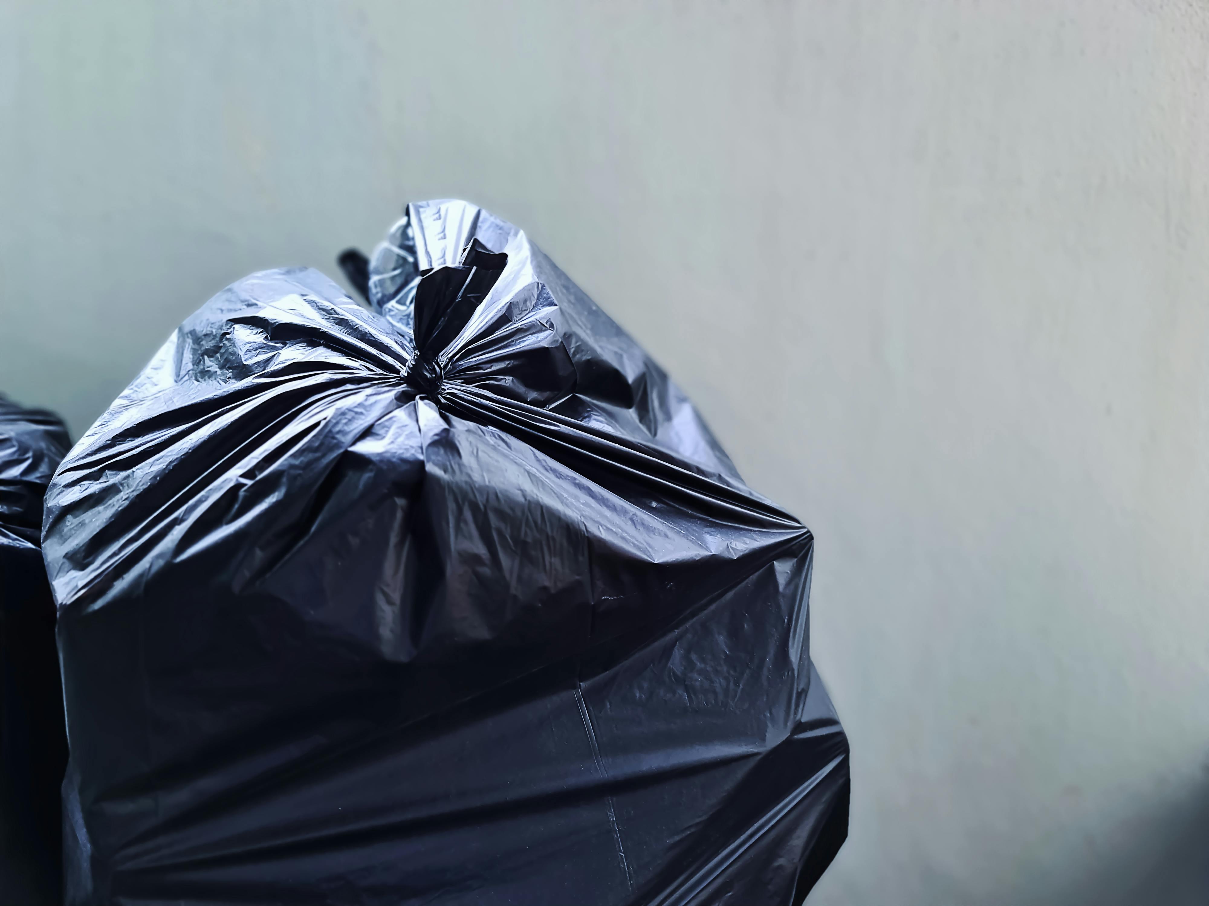 Bolsa de plástico negra cerca de un muro de hormigón | Fuente: Pexels