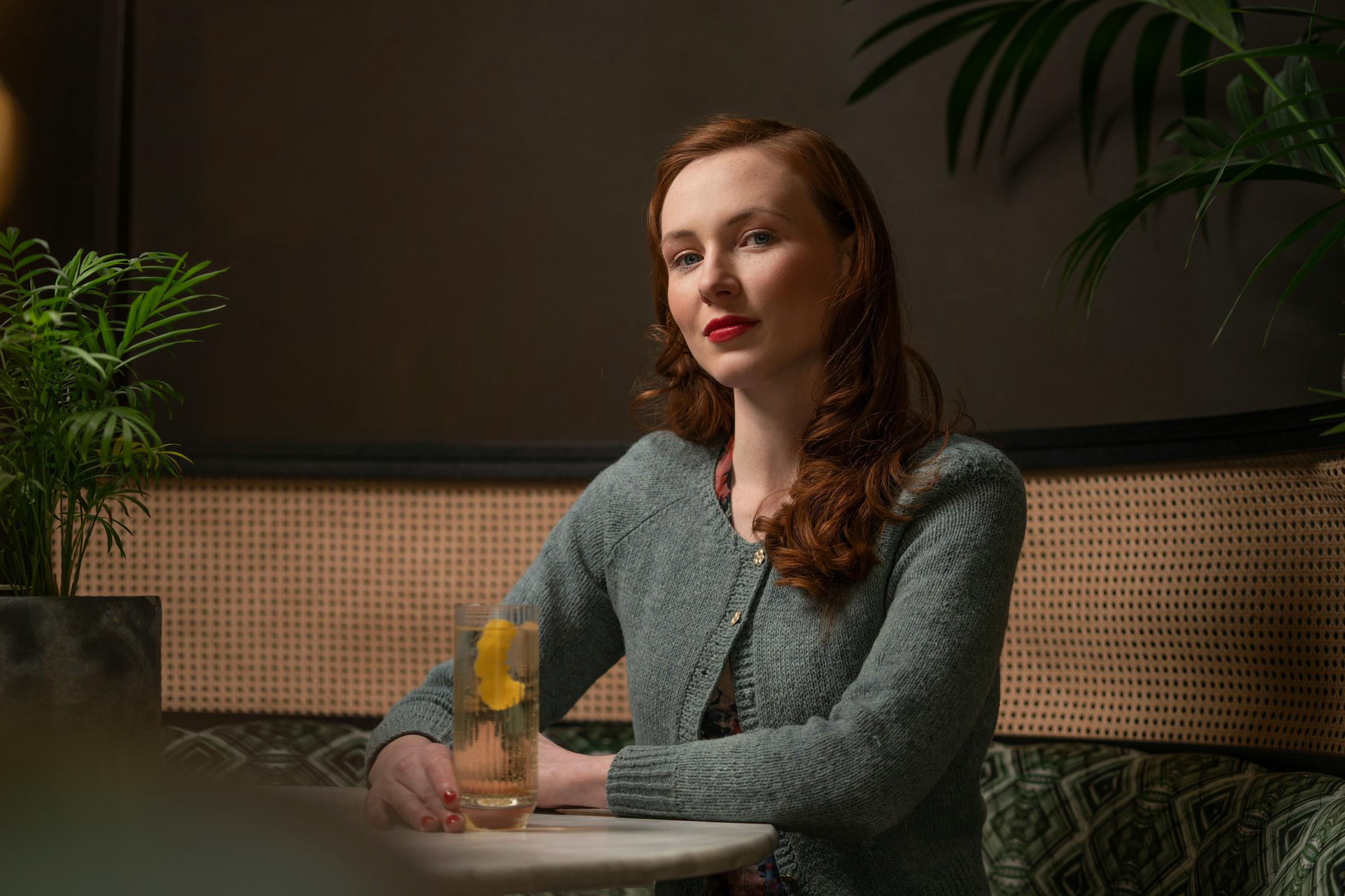 Una mujer sonriente sentada a una mesa | Fuente: Unsplash