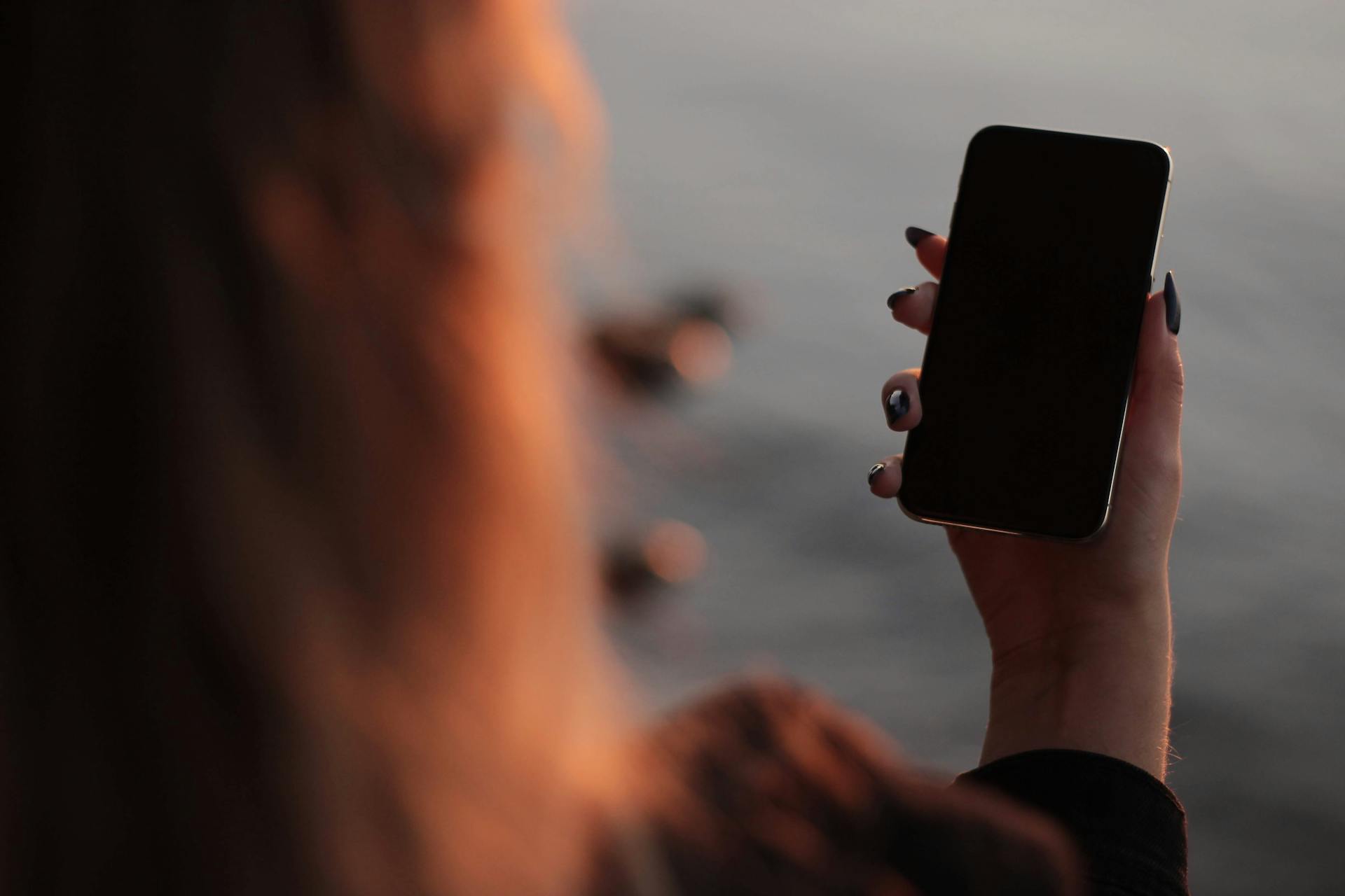 Una mujer con un teléfono en la mano | Fuente: Pexels