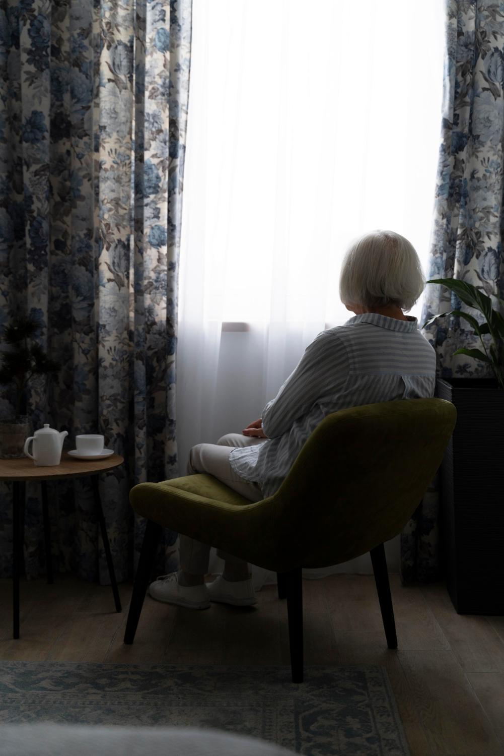 Una mujer mayor y solitaria sentada en una habitación | Fuente: Freepik
