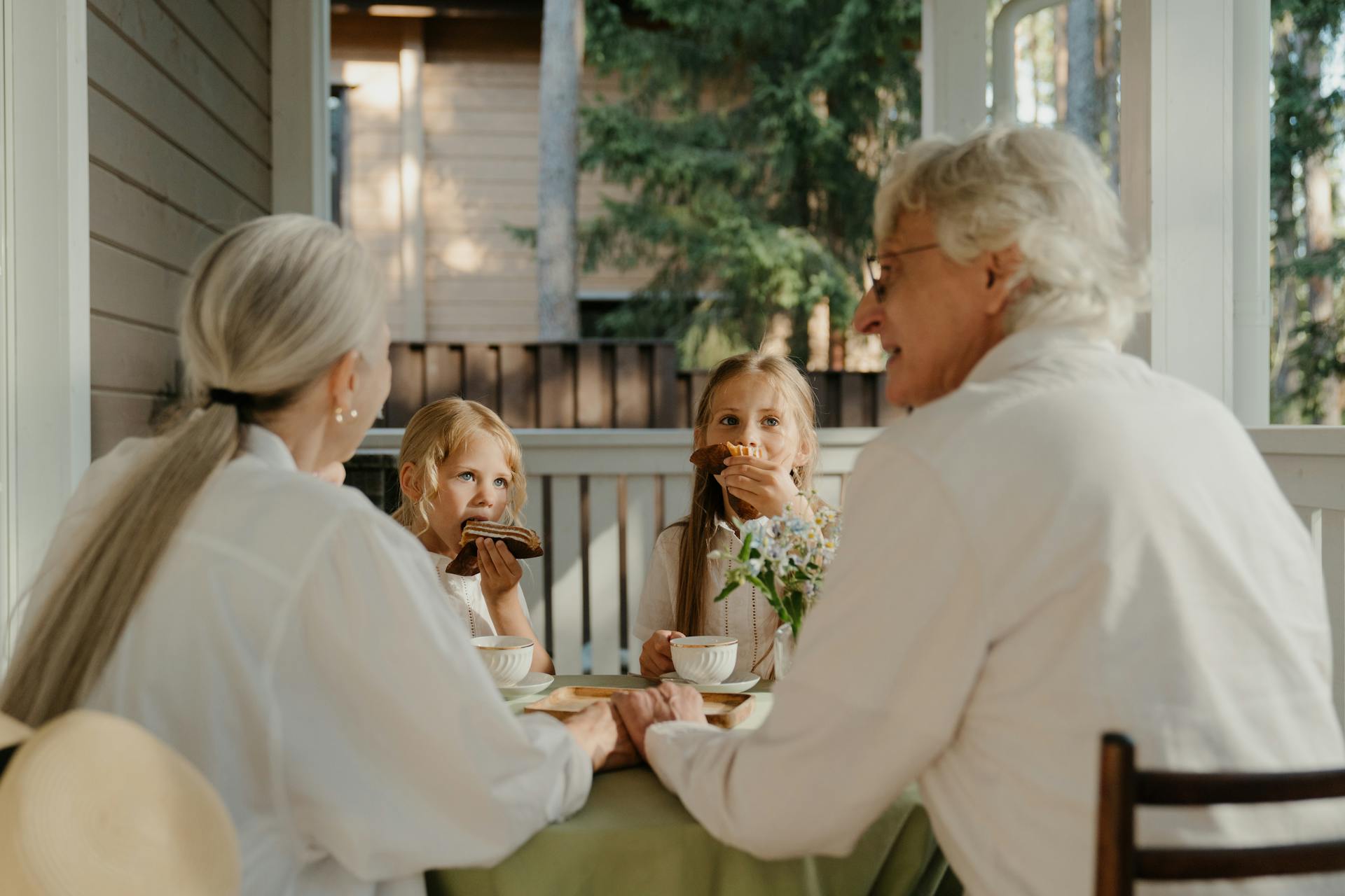 Una pareja mayor comiendo con dos niños | Fuente: Pexels