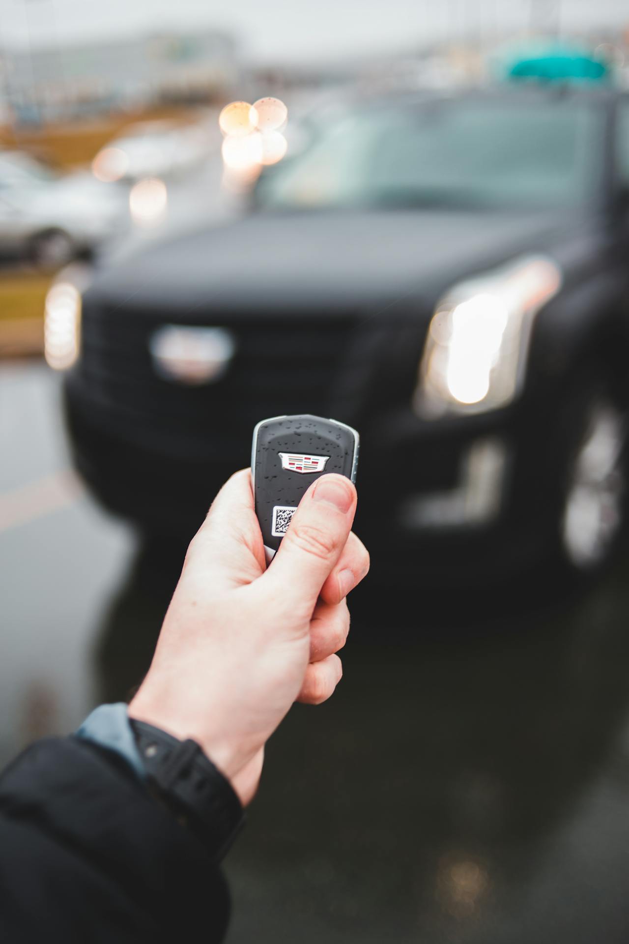 Un hombre sostiene la llave de su automóvil delante de su auto | Fuente: Pexels