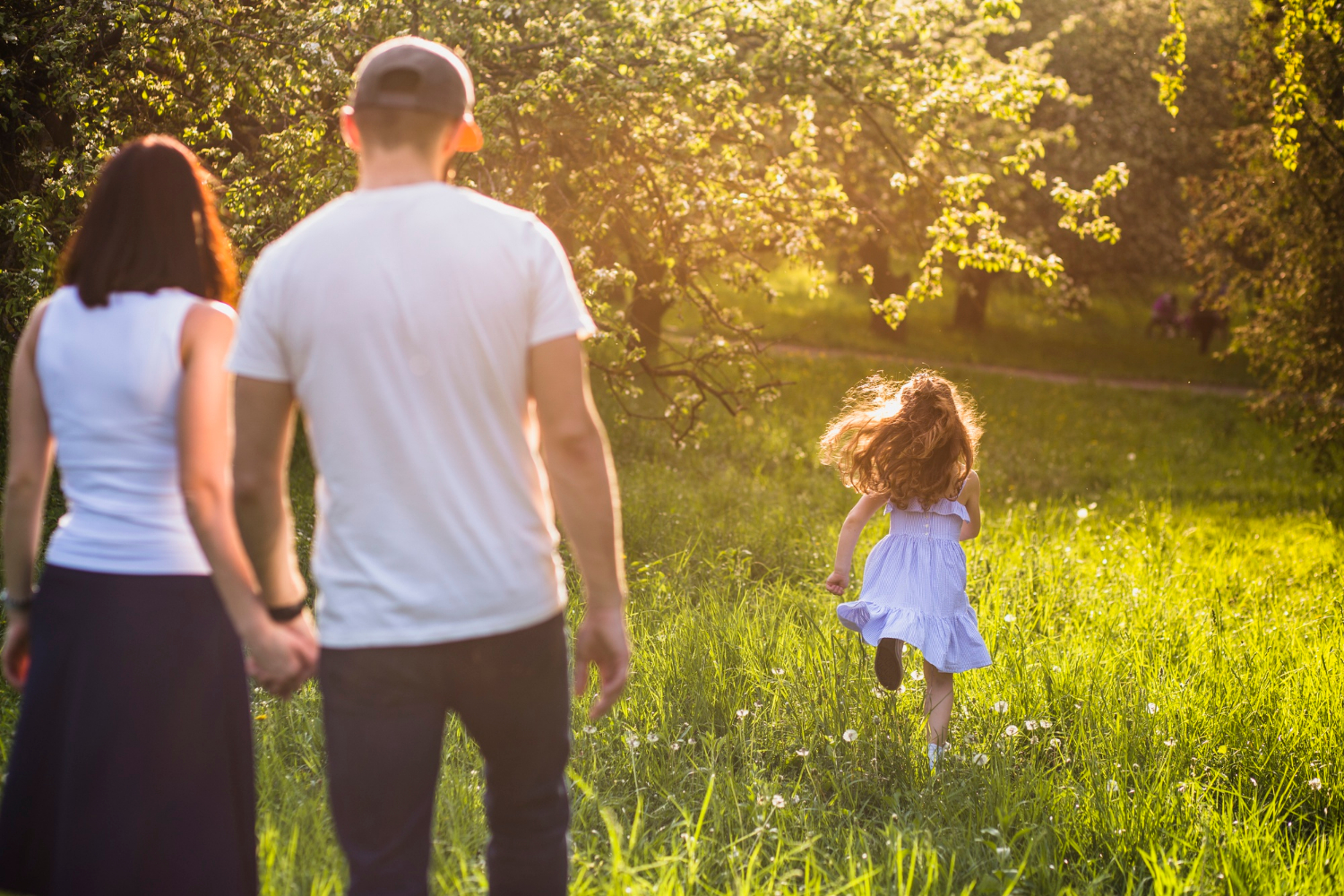 Una pareja observa a su hija corriendo en un parque | Fuente: Freepik