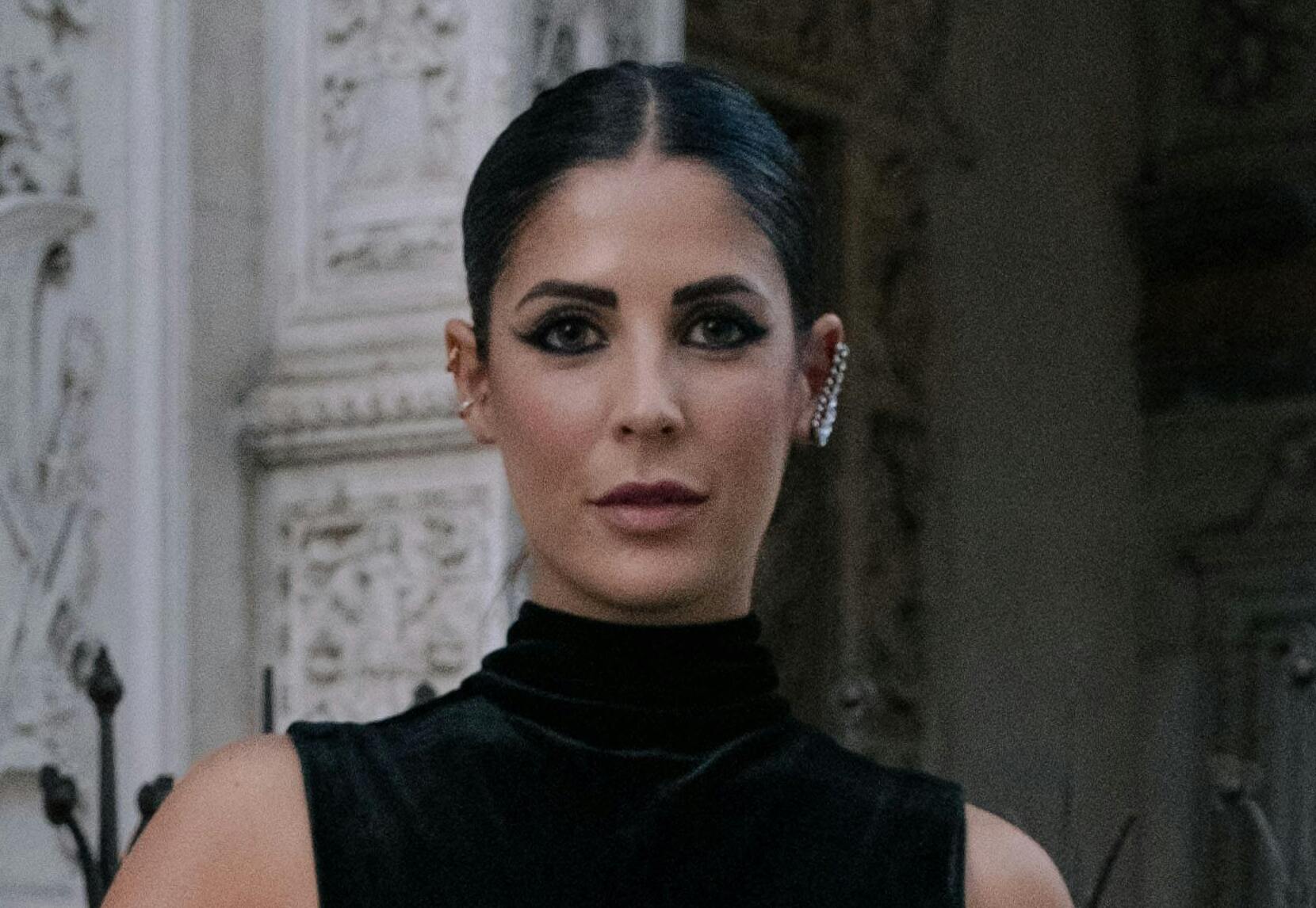 Una mujer con un vestido de terciopelo negro y expresión seria | Fuente: Pexels