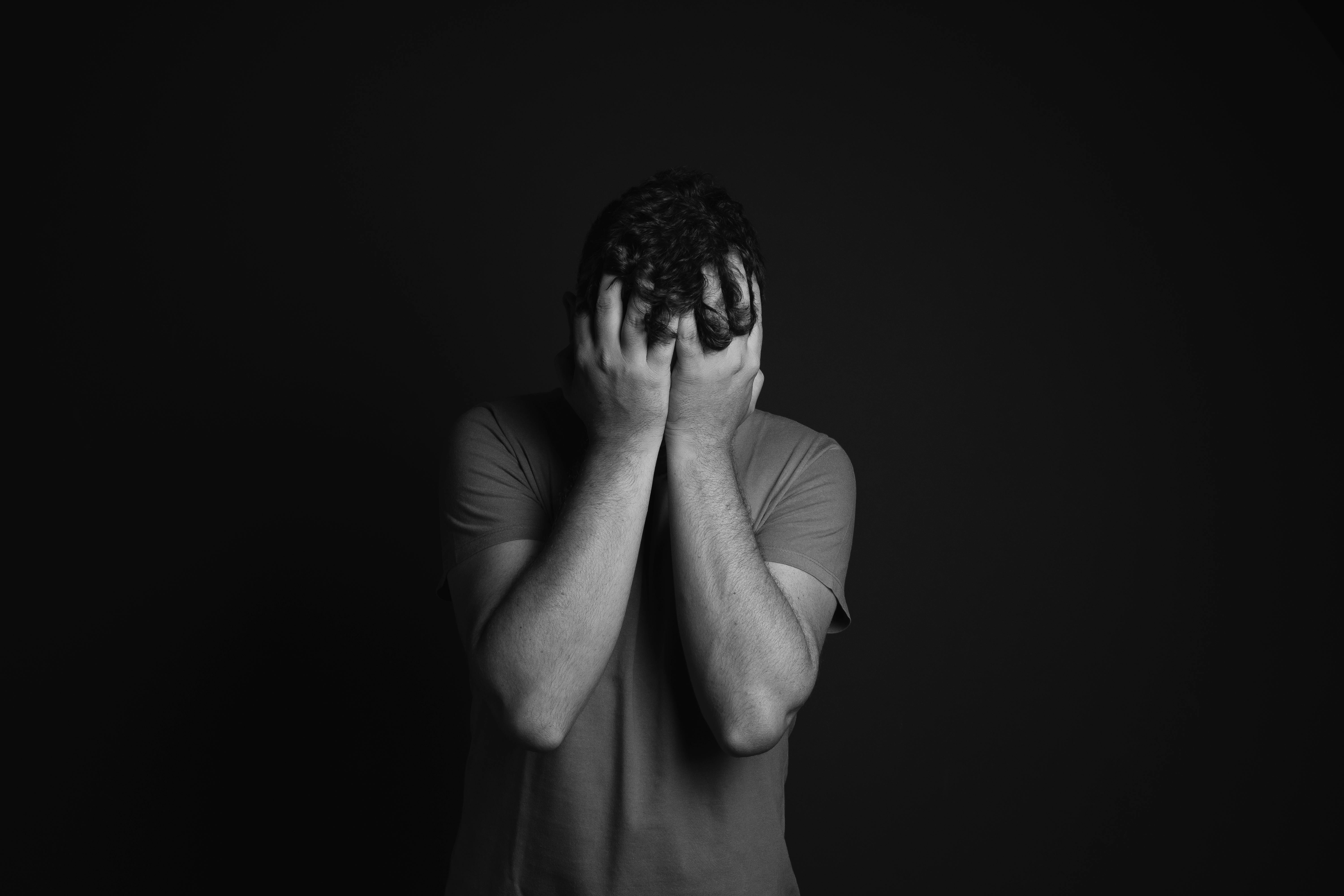 Un hombre triste tapándose la cara | Fuente: Pexels