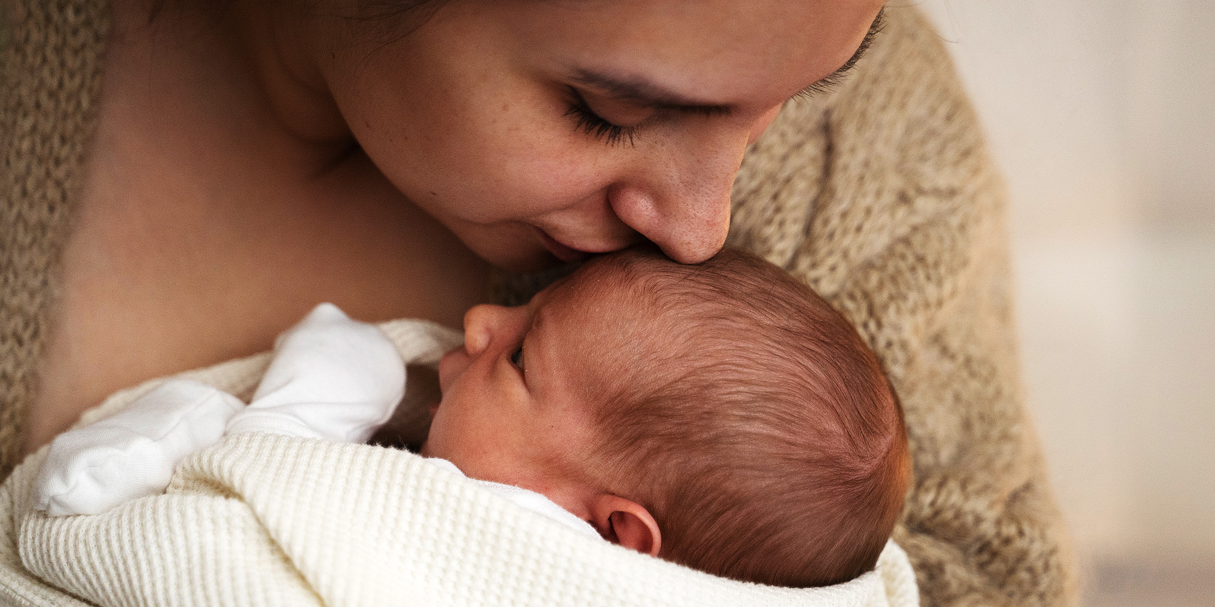 Una mujer besando a su bebé | Fuente: Freepik
