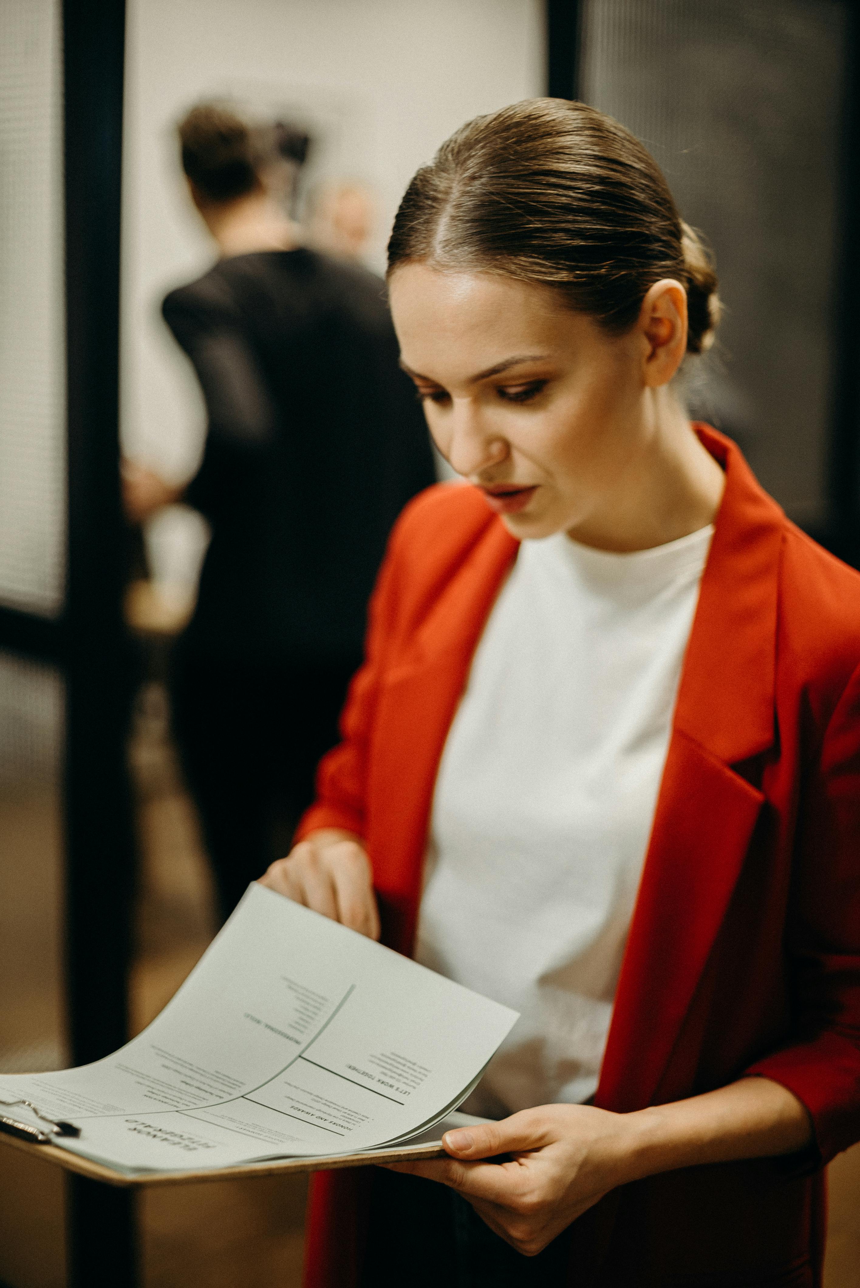 Una mujer sujetando un portapapeles | Fuente: Pexels