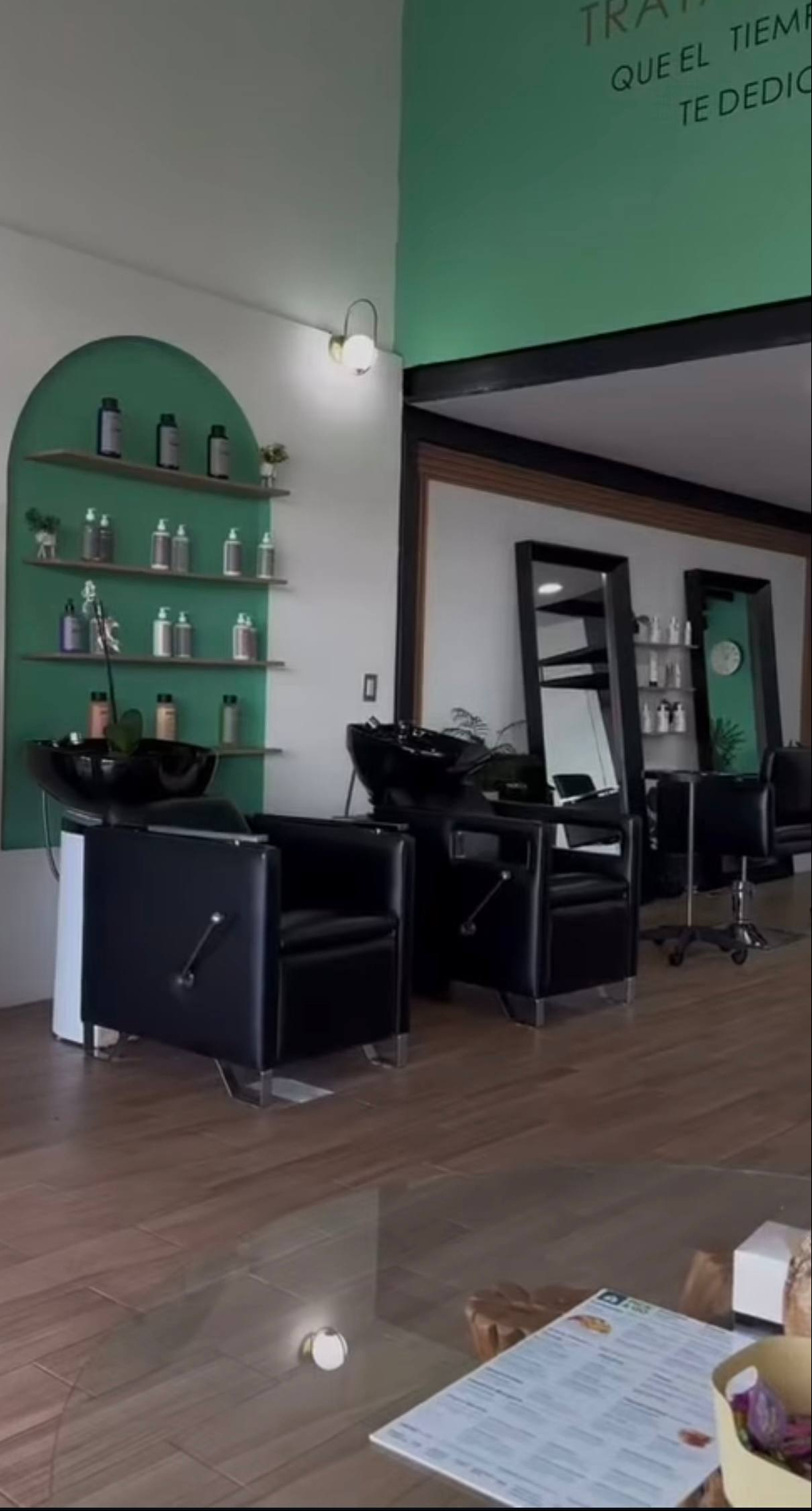 Interior del local de Valeria Márquez con sillas negras ubicadas en lo que parece ser el área de lavado del cabello | Fuente: Instagram/blossom.beauty.ig