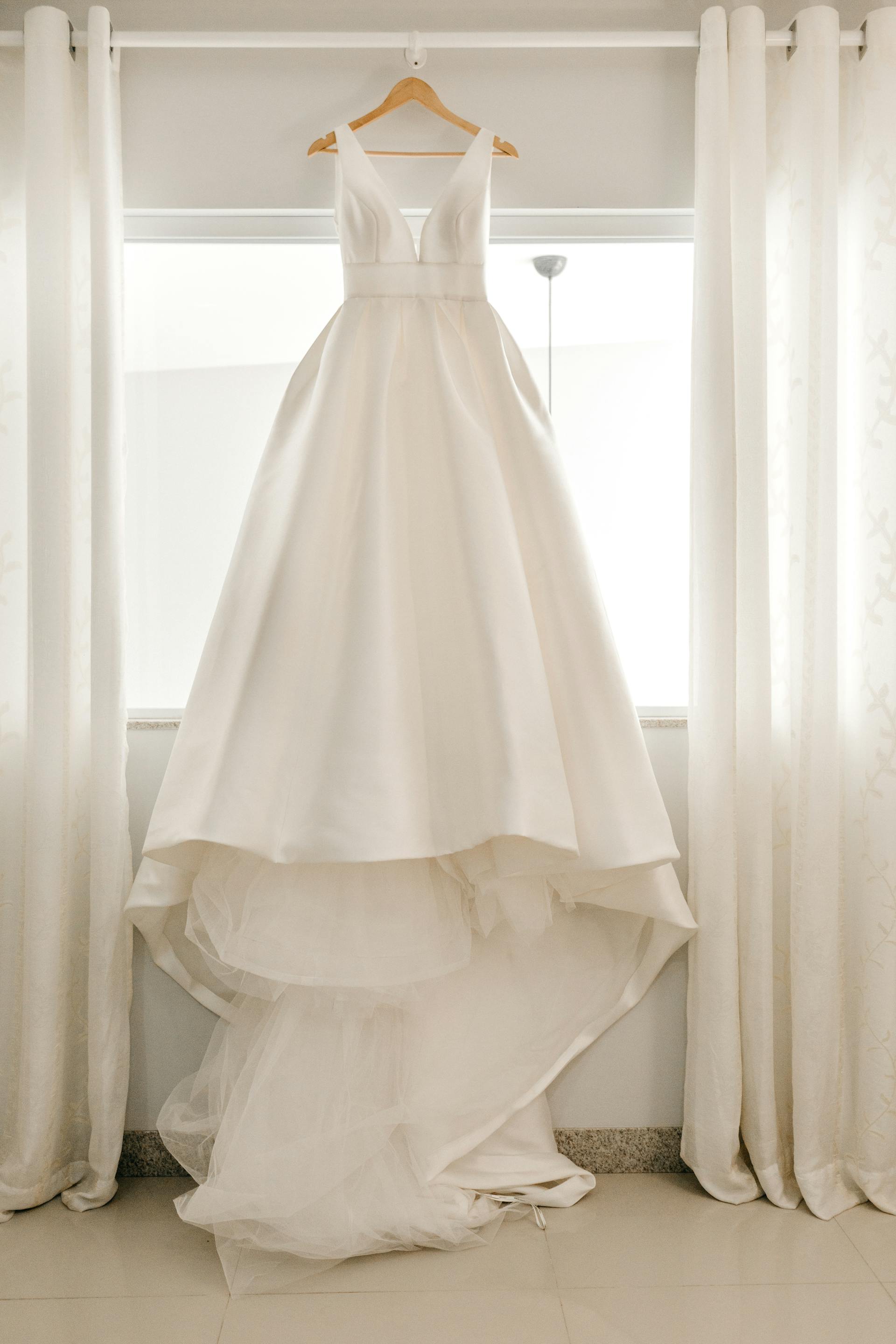 Un vestido de novia colgado de una barra de cortina | Fuente: Pexels