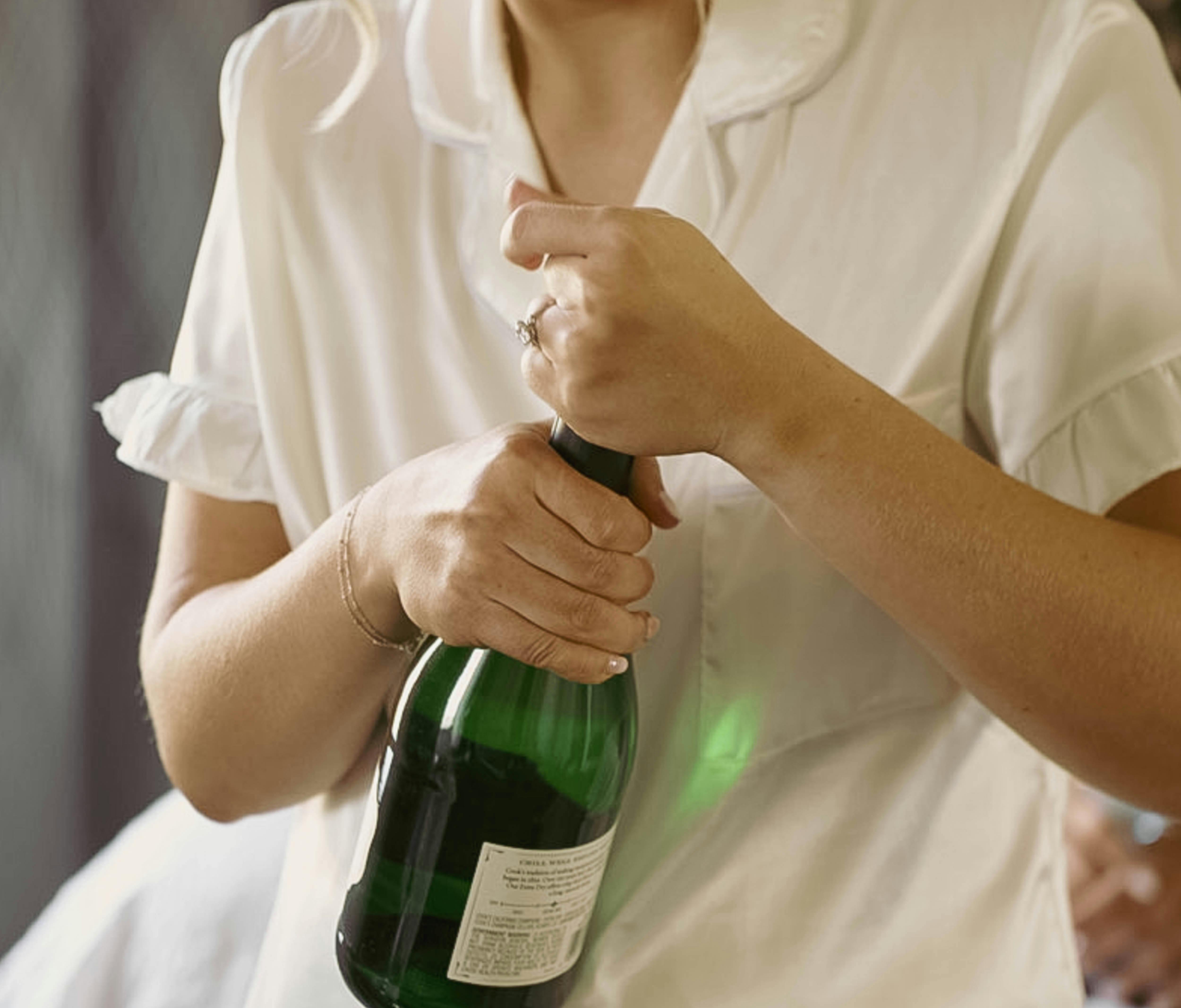 Una persona con una botella de champán en la mano | Fuente: Pexels