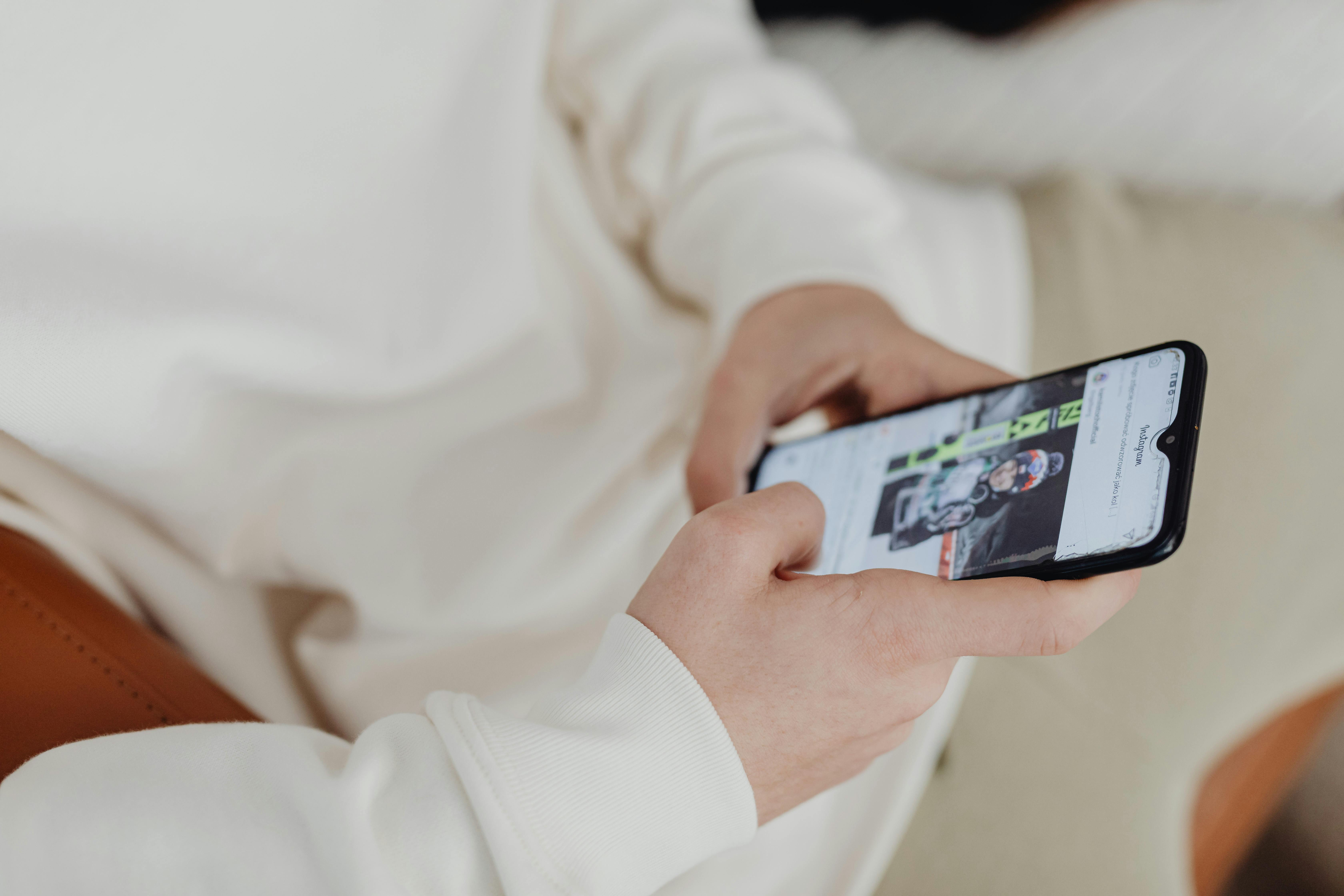 Una persona sujetando su teléfono | Fuente: Pexels