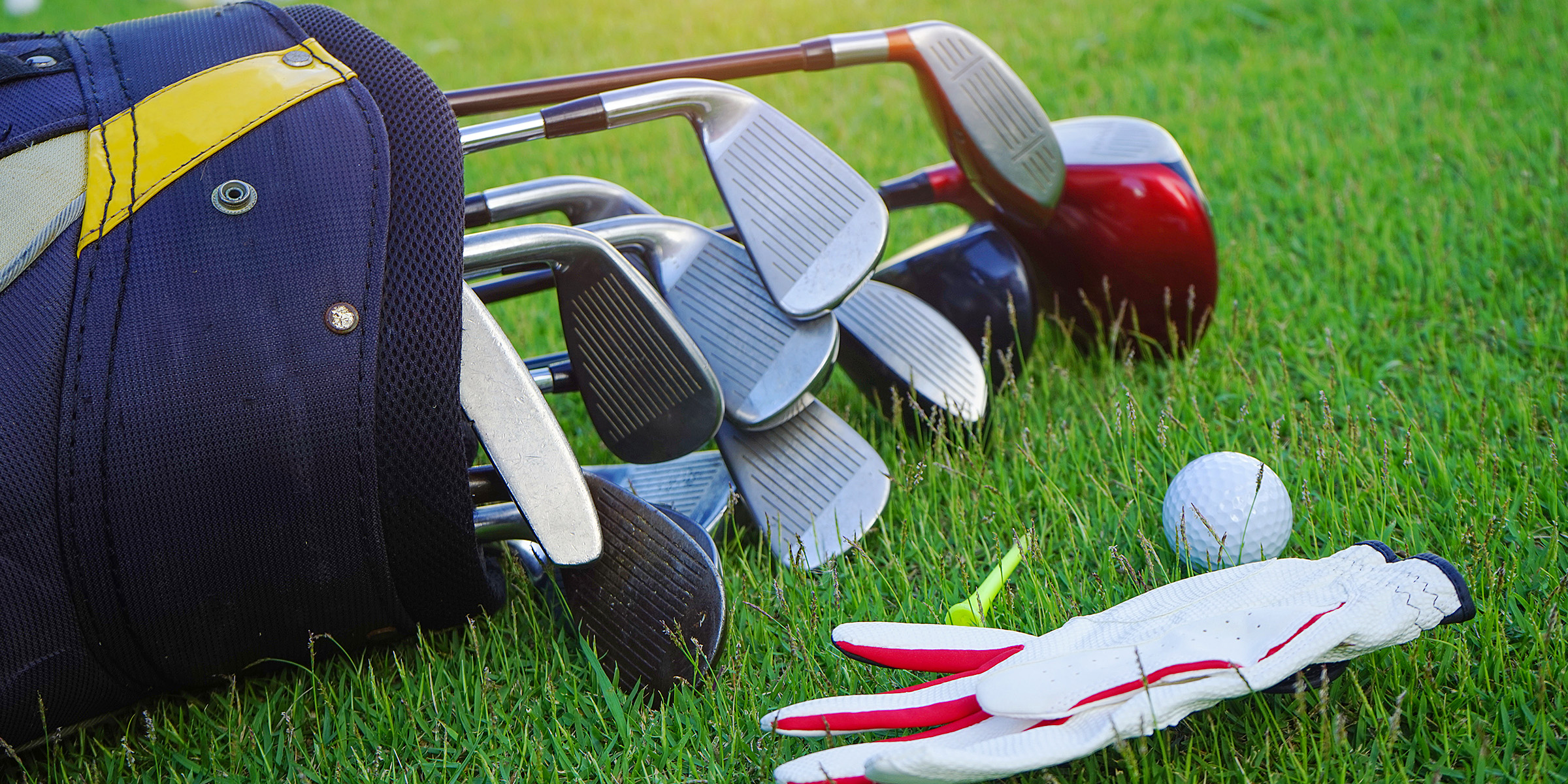 Palos y una pelota de golf sobre la hierba | Fuente: Shutterstock