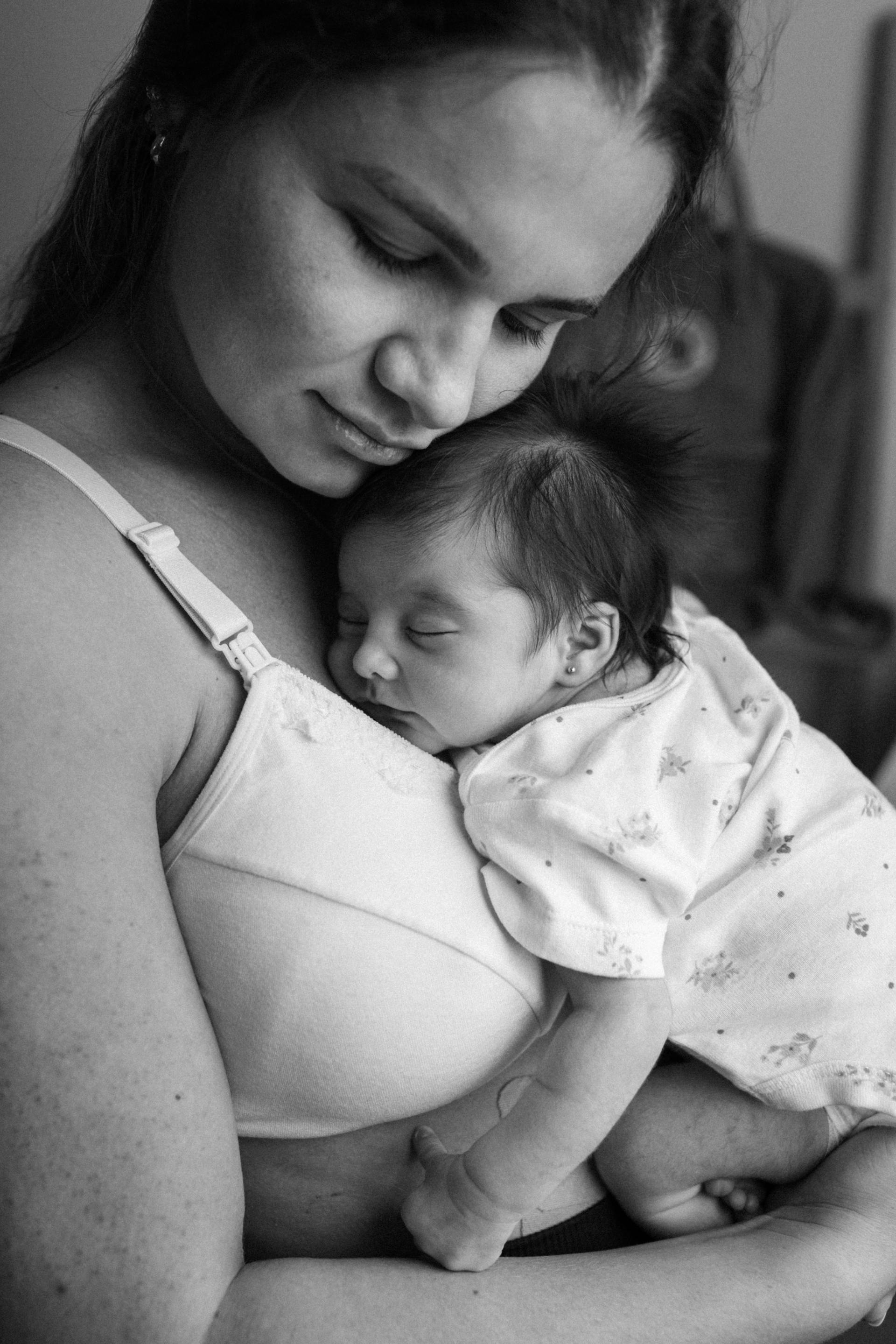 Una madre abrazando a su bebé dormida | Fuente: Pexels