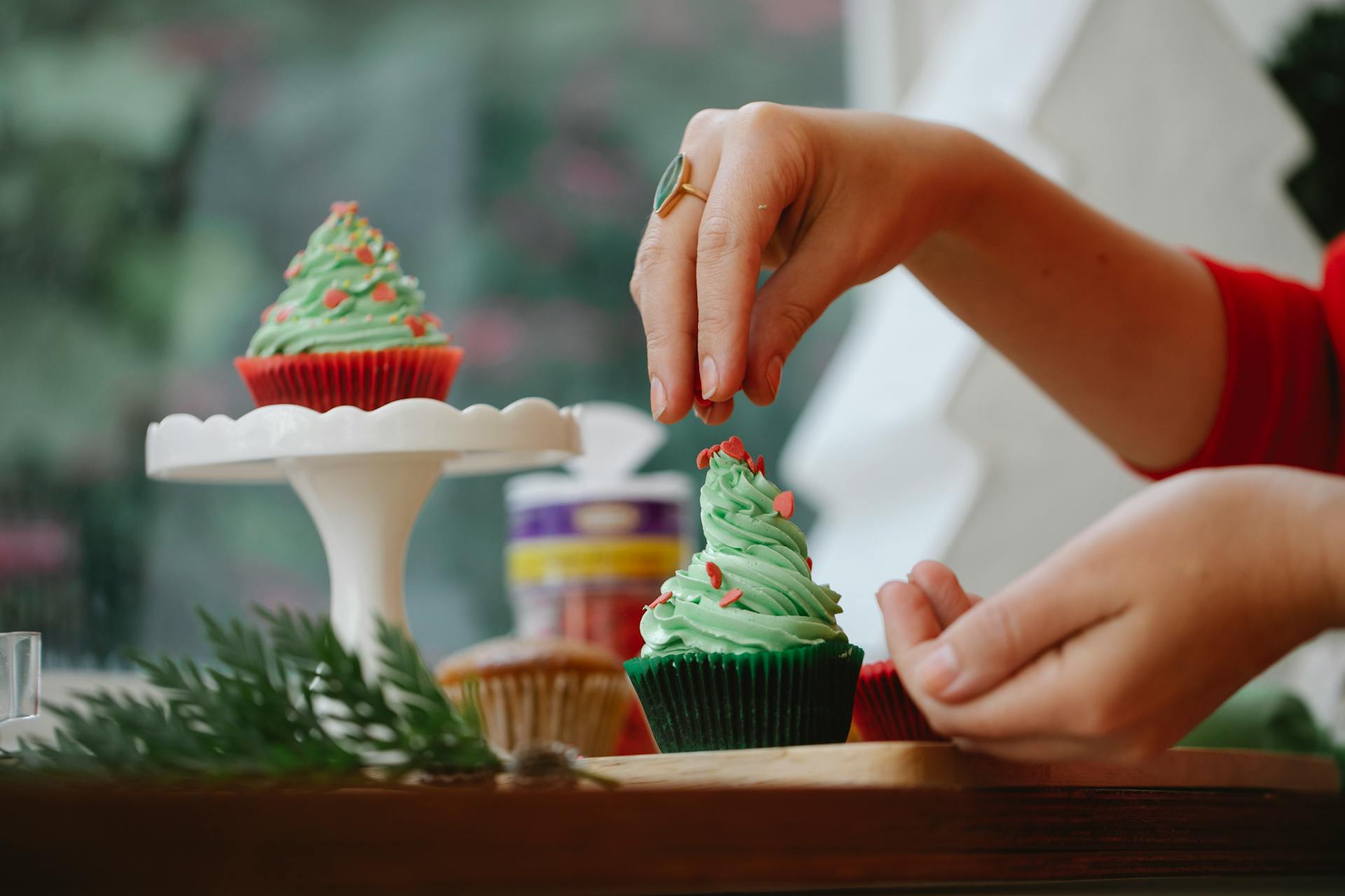 Una mujer decorando magdalenas | Fuente: Pexels
