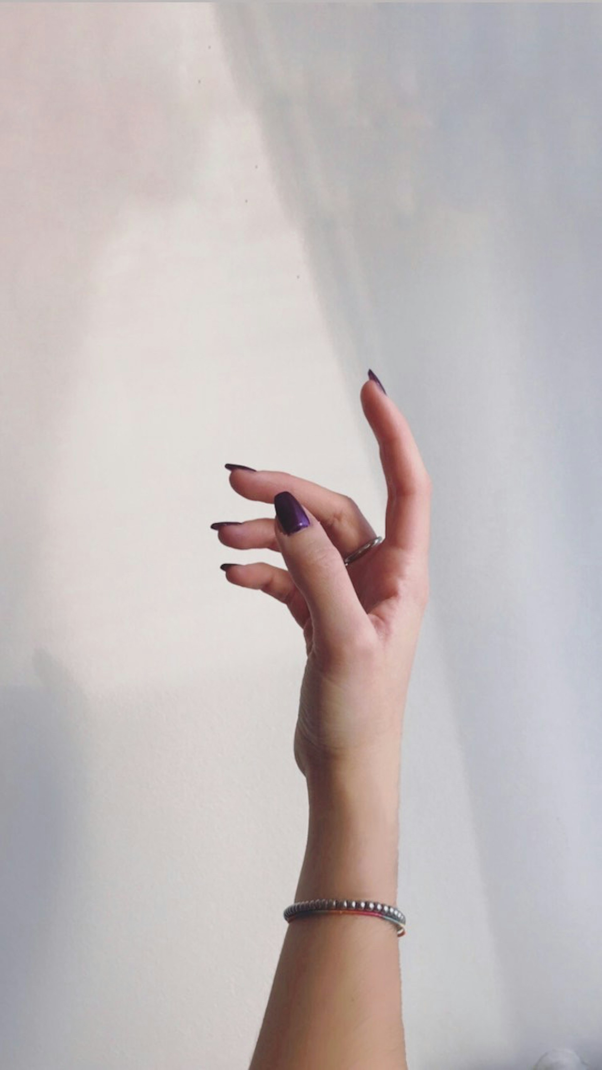 La mano de una mujer tendida hacia una pared | Fuente: Unsplash