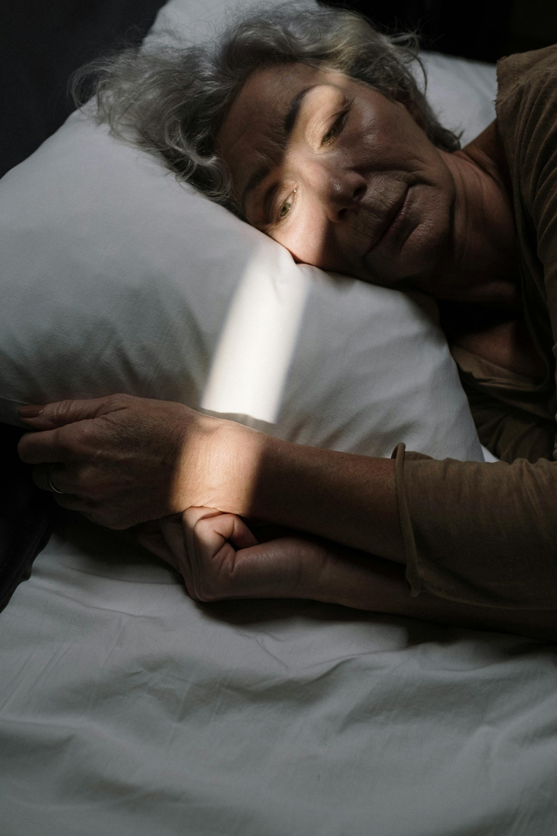 Una anciana triste despierta en la cama | Fuente: Pexels