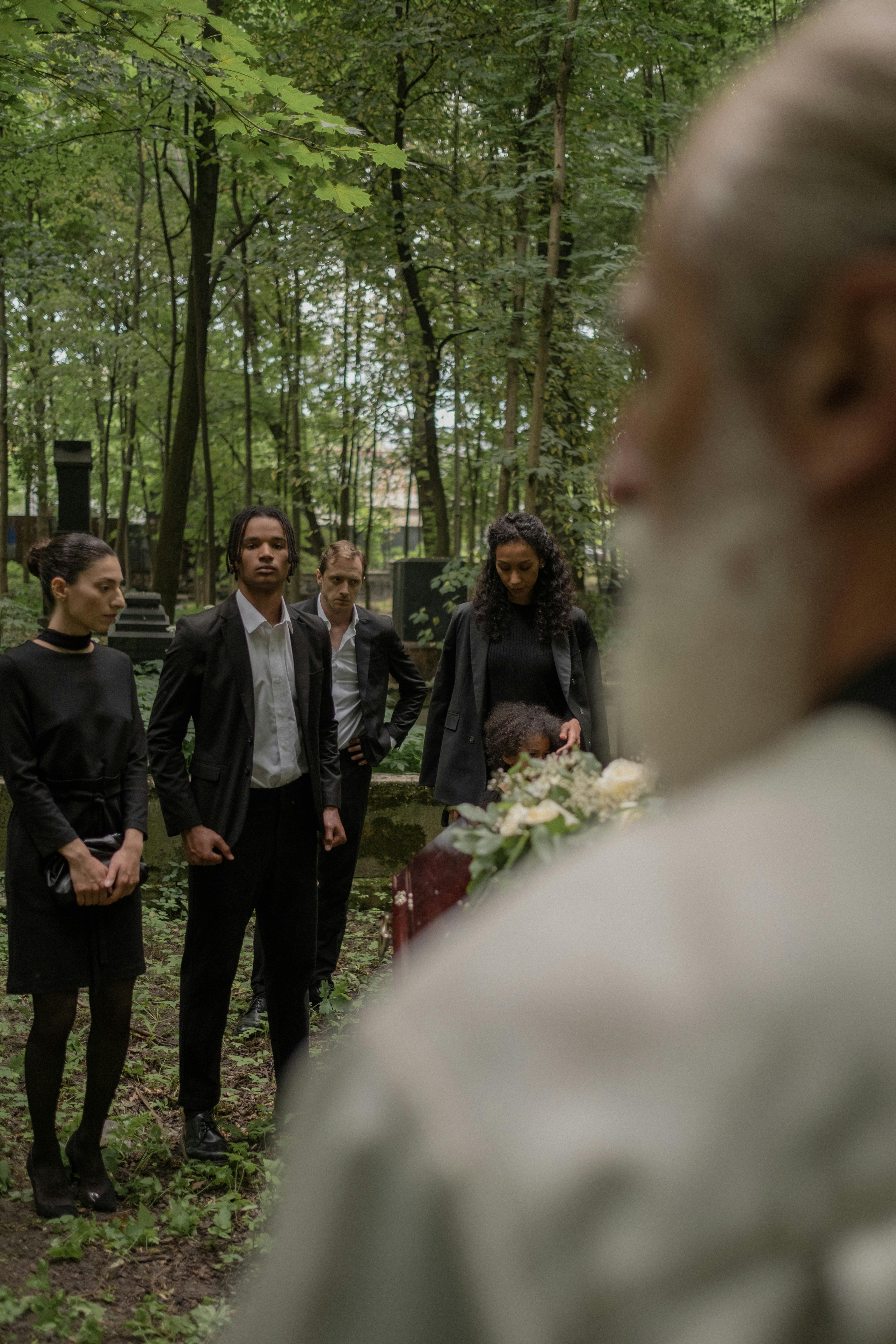 Gente de pie en un cementerio | Fuente: Pexels