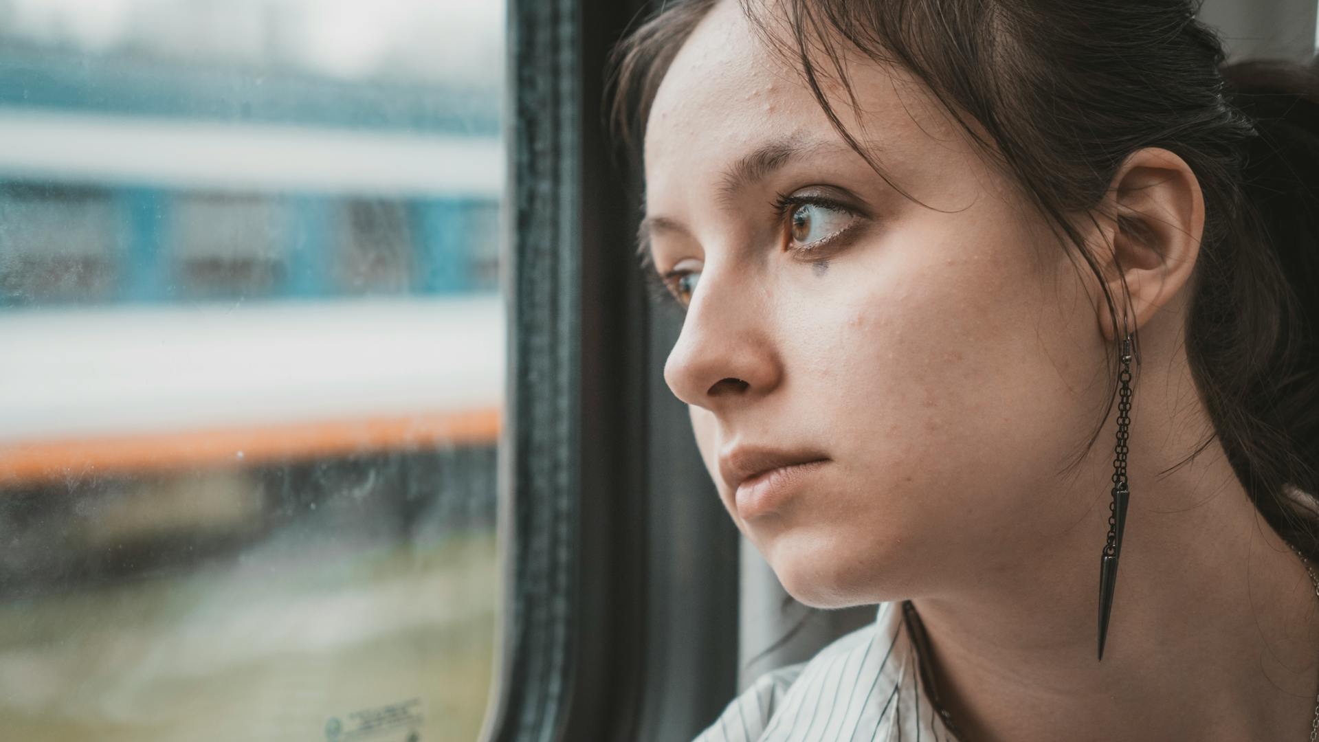 Una mujer mirando preocupada por una ventana | Fuente: Pexels