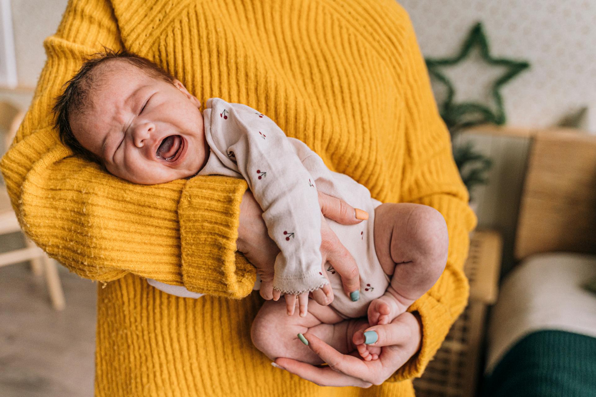 Una mujer con un bebé llorando en brazos | Fuente: Pexels