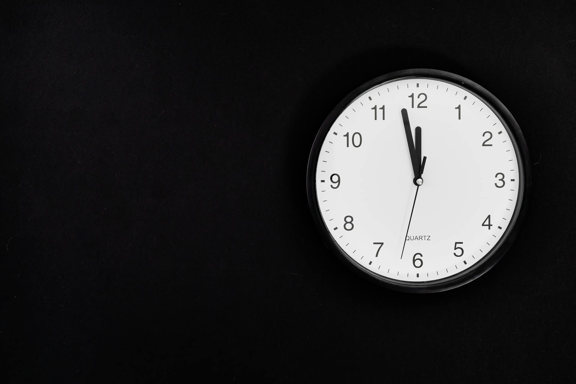 Un viejo reloj de pared analógico que muestra las 11:58 p.m. | Fuente: Pexels