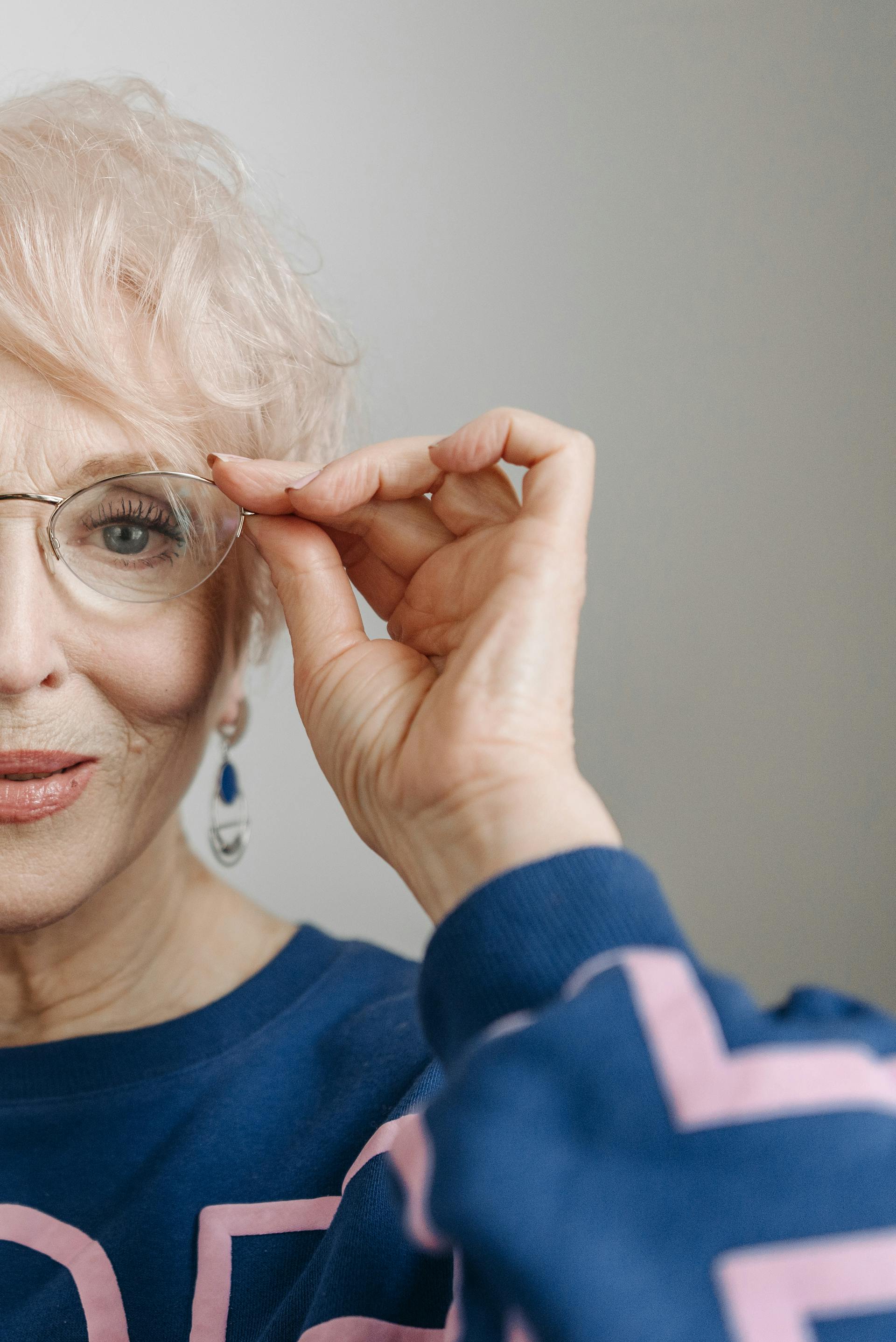 Primer plano de una anciana tocándose las gafas | Fuente: Pexels