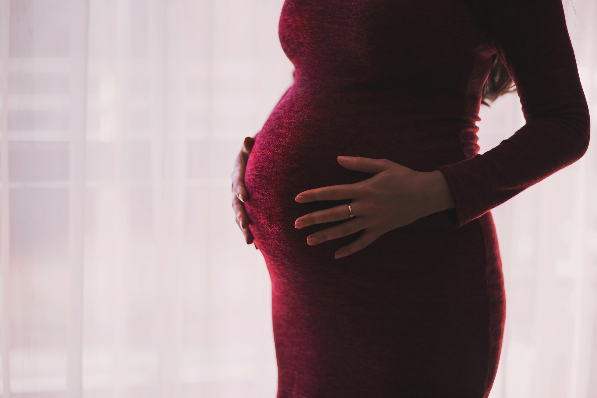 Imagen recortada de una mujer embarazada sujetándose el vientre | Fuente: Unsplash